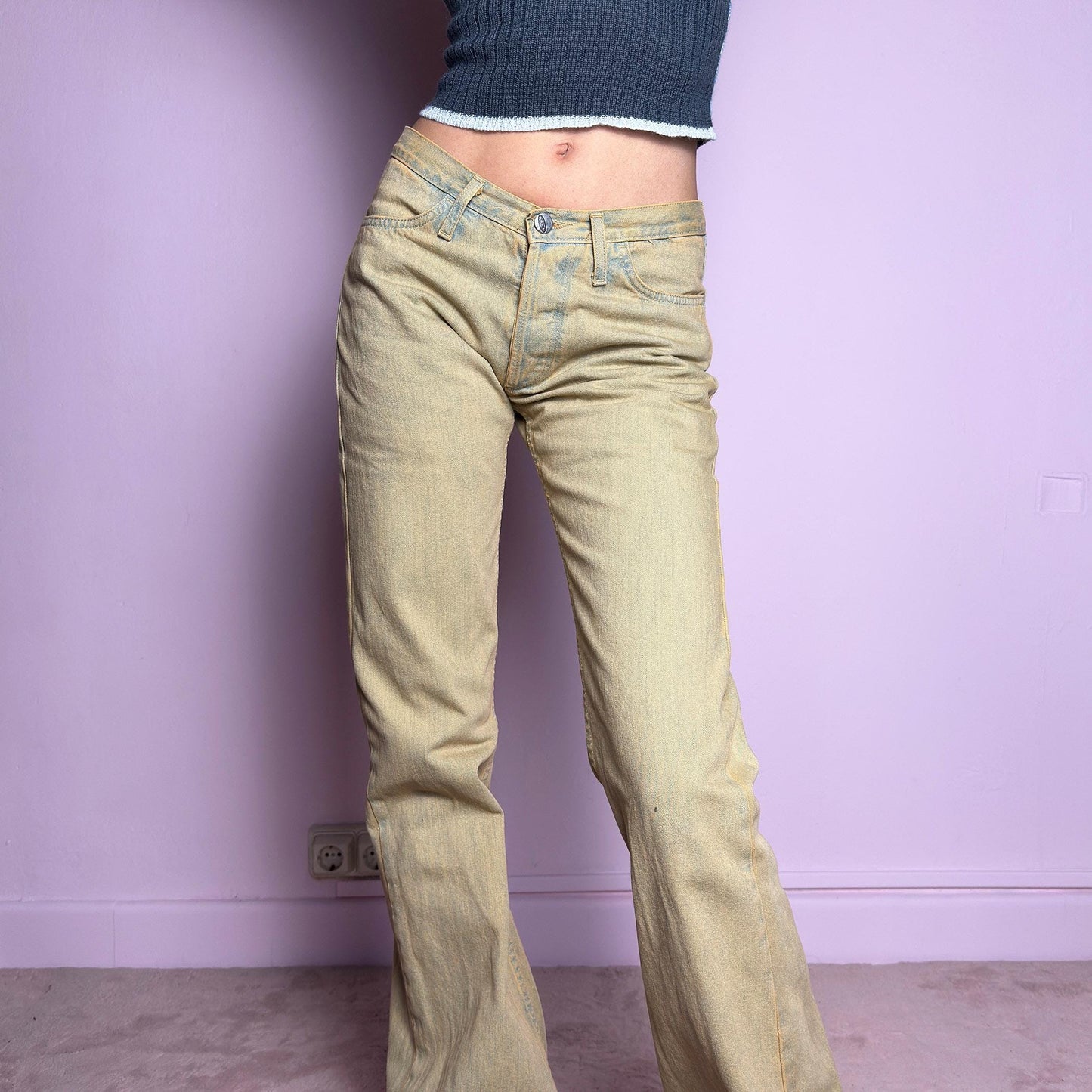 The Y2K Low-Rise Flare Jeans are a vintage 2000s staple featuring a structured denim fabric in a muted earthy tone with a slightly washed effect. Designed with a flattering low-rise fit, button closure, pockets and a flared leg that creates a sleek silhouette, these jeans are perfect for casual outfits. adult world shop