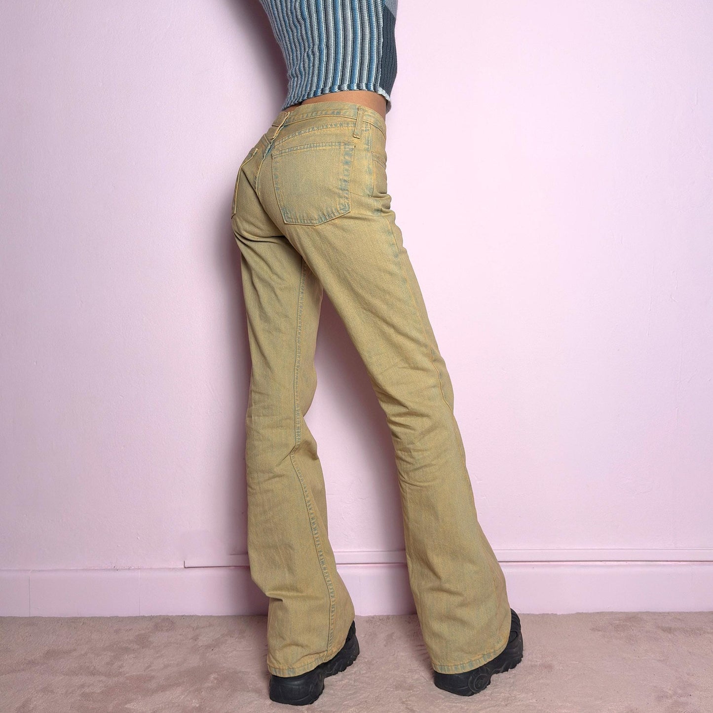 The Y2K Low-Rise Flare Jeans are a vintage 2000s staple featuring a structured denim fabric in a muted earthy tone with a slightly washed effect. Designed with a flattering low-rise fit, button closure, pockets and a flared leg that creates a sleek silhouette, these jeans are perfect for casual outfits. adult world shop