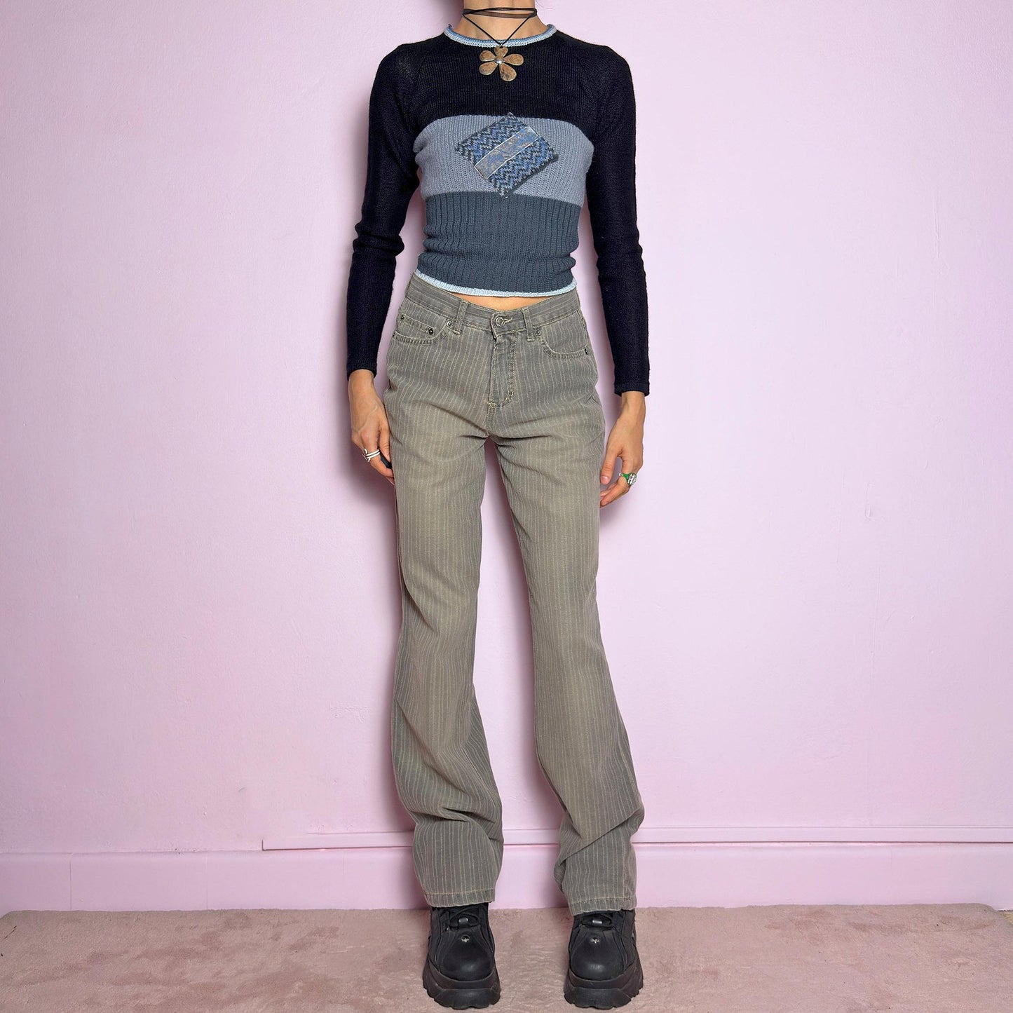 The Y2K Gray Straight Jeans are a vintage 2000s essential featuring a structured fabric with subtle pinstripes. Designed with a relaxed straight-leg fit, a flattering high waist, button and zipper closure, and pockets, these jeans offer a sleek yet effortless silhouette. Perfect for casual outfits. adult world shop