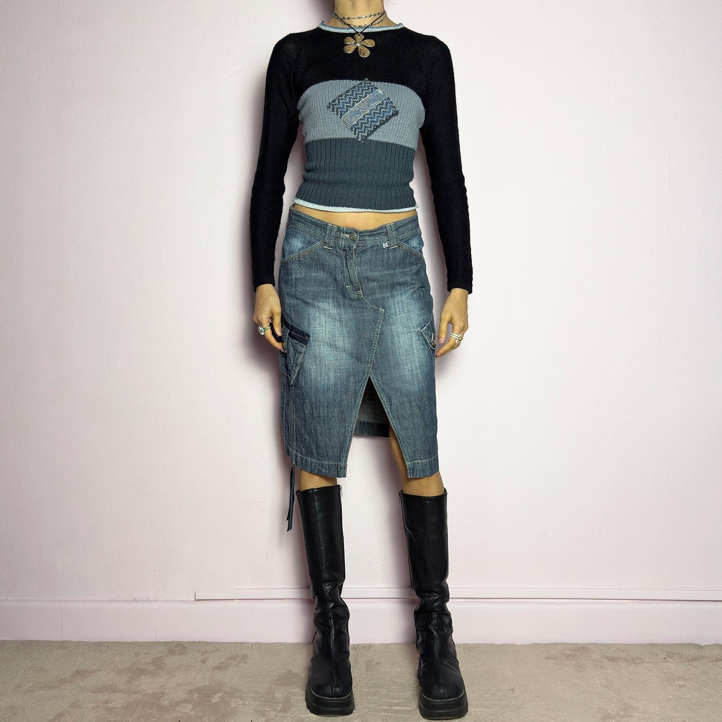 The Y2K Deconstructed Denim Midi Skirt is a vintage 2000s standout piece featuring a structured dark-wash denim fabric with contrast stitching. Designed with an asymmetrical front slit, utility-style cargo pockets, and adjustable drawstrings. Finished with a button and zipper closure, belt loops, and a mid-length silhouette, it's perfect for effortless grunge and utilitarian-inspired outfits. adult world shop