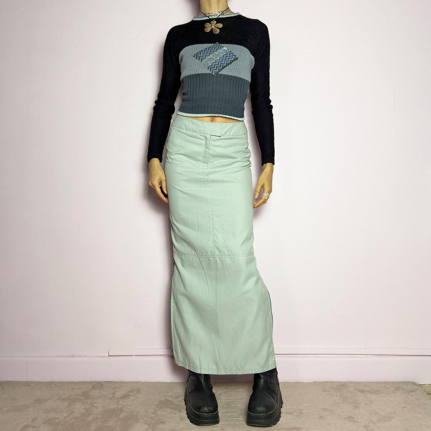 The Y2K Light Gray Maxi Skirt is a vintage 2000s piece with a sleek, futuristic aesthetic. Featuring a structured fit, and a high-rise waist, this skirt is designed for a modern, minimal look. Made from lightweight fabric, it offers a flattering silhouette with dual side zipper slits for adjustable styling. Perfect for casual, streetwear, or cyber-inspired avant-garde outfits. adult world shop