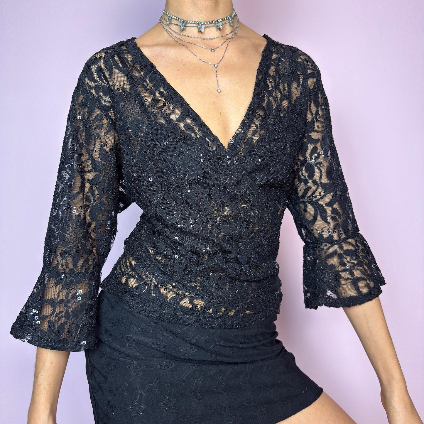 The Y2K Black Lace Tie Bolero is a vintage 2000s sheer tie-front top crafted in delicate floral lace with subtle sequin accents. Features flared three-quarter sleeves for a dreamy silhouette and an adjustable tie at the front for versatile styling. Ideal for summer nights, festivals, or clubwear looks. adult world shop