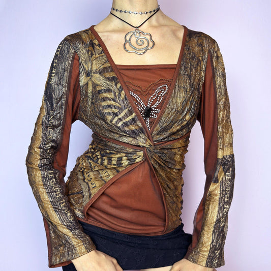 The Y2K Brown Mesh Overlay Top is a vintage 2000s long sleeve designed by Legatte Jeans. Crafted in a moody mix of orange, brown, and bronze tones, it features a twisted front detail and a combination of stretchy mesh and jersey fabrics. A subtle embroidered flower motif decorates the chest, adding a delicate accent to the bold, structured silhouette. With its sculptural cut and sheer elements, this top is perfect for cyber aesthetics, artsy fashion, and Y2K clubwear. adult world shop