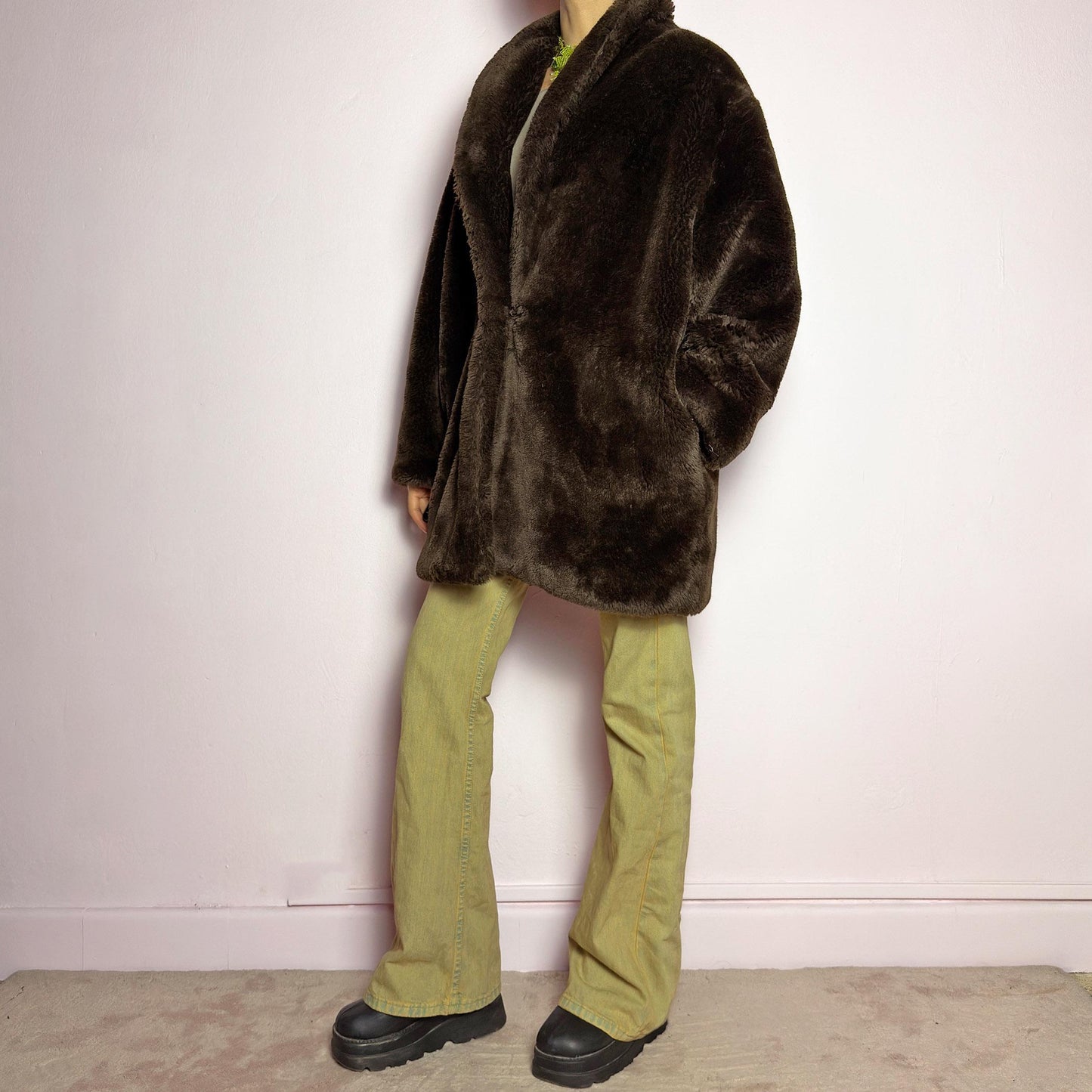 The Vintage 90s Brown Faux Fur Coat is a luxurious and cozy statement piece. Featuring a soft plush texture, and a deep chocolate brown hue, this coat exudes effortless elegance and warmth. Designed with a relaxed fit, pockets, and a hidden hook closure, it's perfect for layering over casual or dressed-up winter outfits. Made in Spain. adult world shop