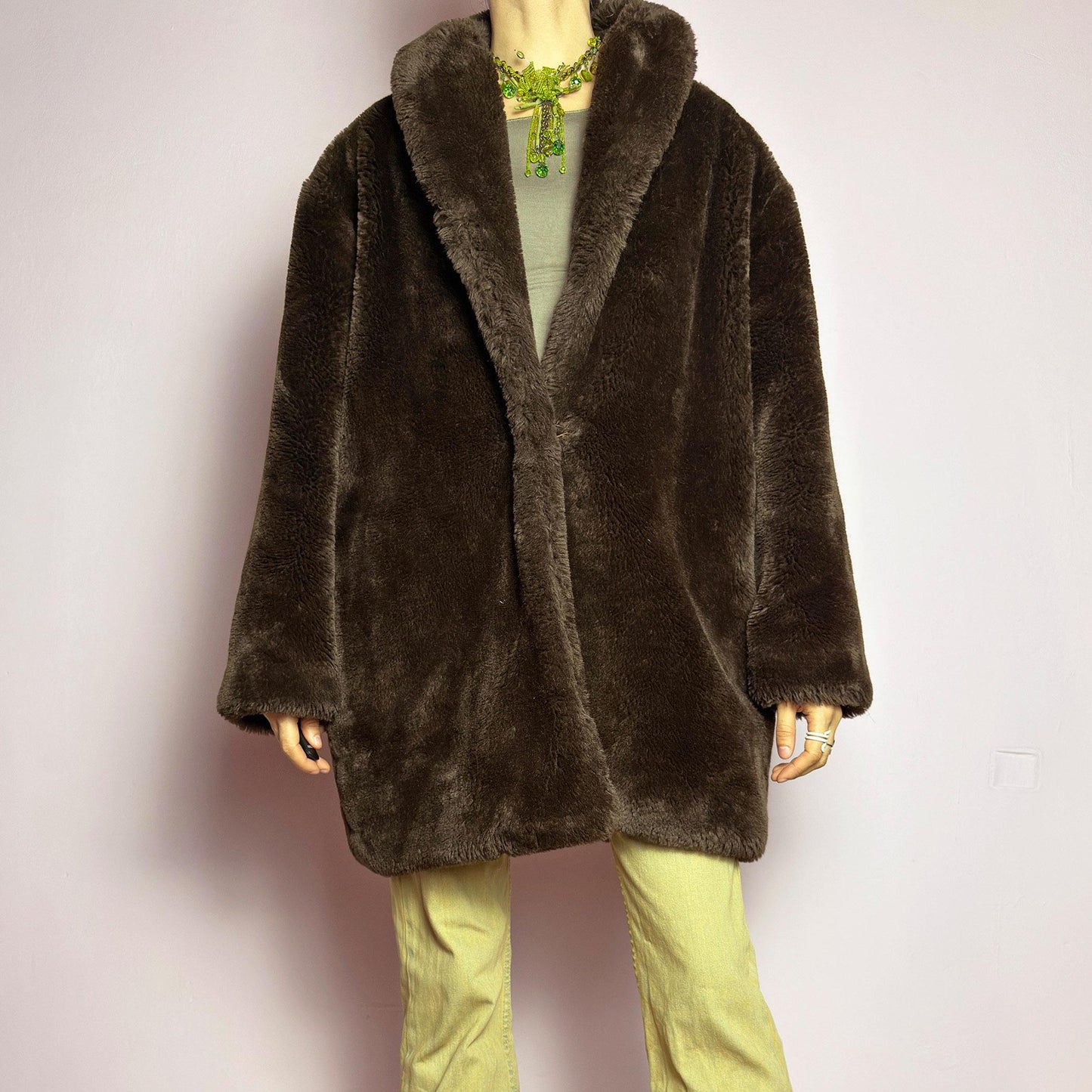 The Vintage 90s Brown Faux Fur Coat is a luxurious and cozy statement piece. Featuring a soft plush texture, and a deep chocolate brown hue, this coat exudes effortless elegance and warmth. Designed with a relaxed fit, pockets, and a hidden hook closure, it's perfect for layering over casual or dressed-up winter outfits. Made in Spain. adult world shop