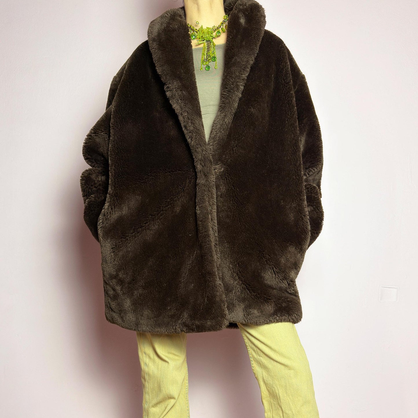 The Vintage 90s Brown Faux Fur Coat is a luxurious and cozy statement piece. Featuring a soft plush texture, and a deep chocolate brown hue, this coat exudes effortless elegance and warmth. Designed with a relaxed fit, pockets, and a hidden hook closure, it's perfect for layering over casual or dressed-up winter outfits. Made in Spain. adult world shop