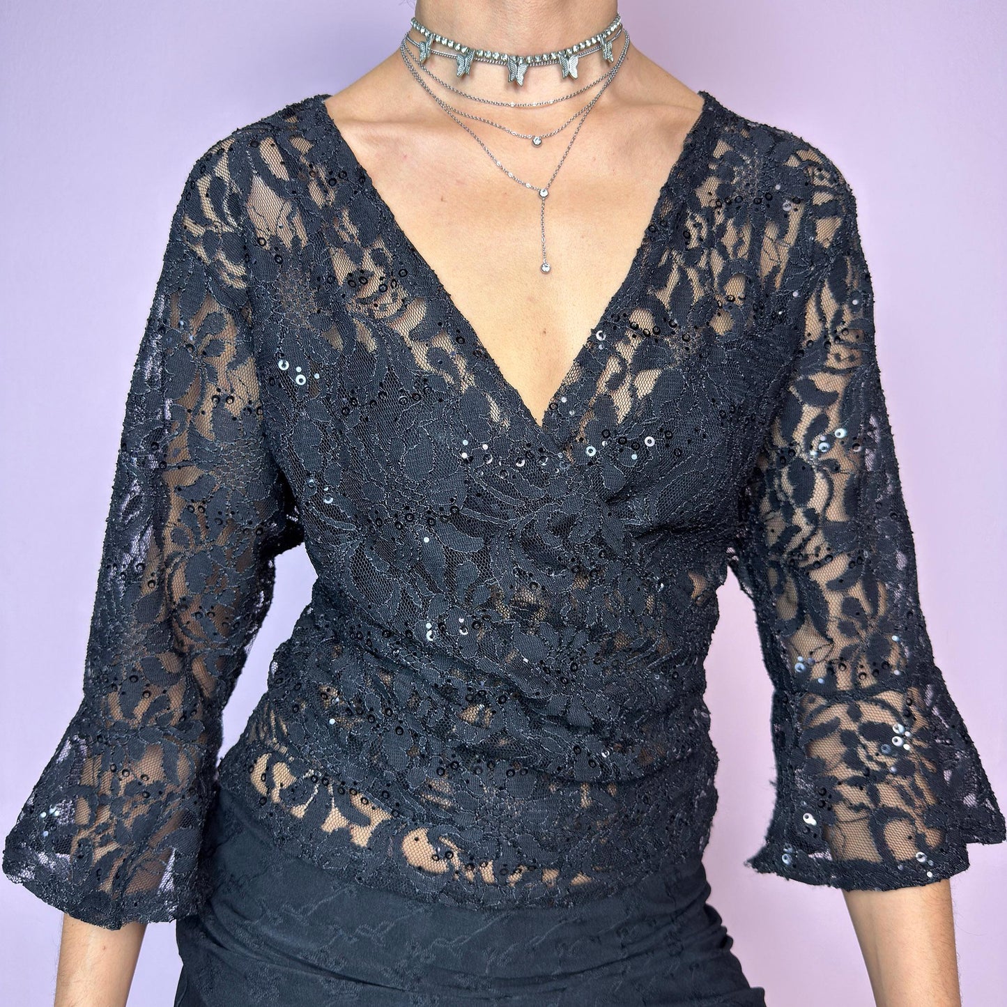 The Y2K Black Lace Tie Bolero is a vintage 2000s sheer tie-front top crafted in delicate floral lace with subtle sequin accents. Features flared three-quarter sleeves for a dreamy silhouette and an adjustable tie at the front for versatile styling. Ideal for summer nights, festivals, or clubwear looks. adult world shop
