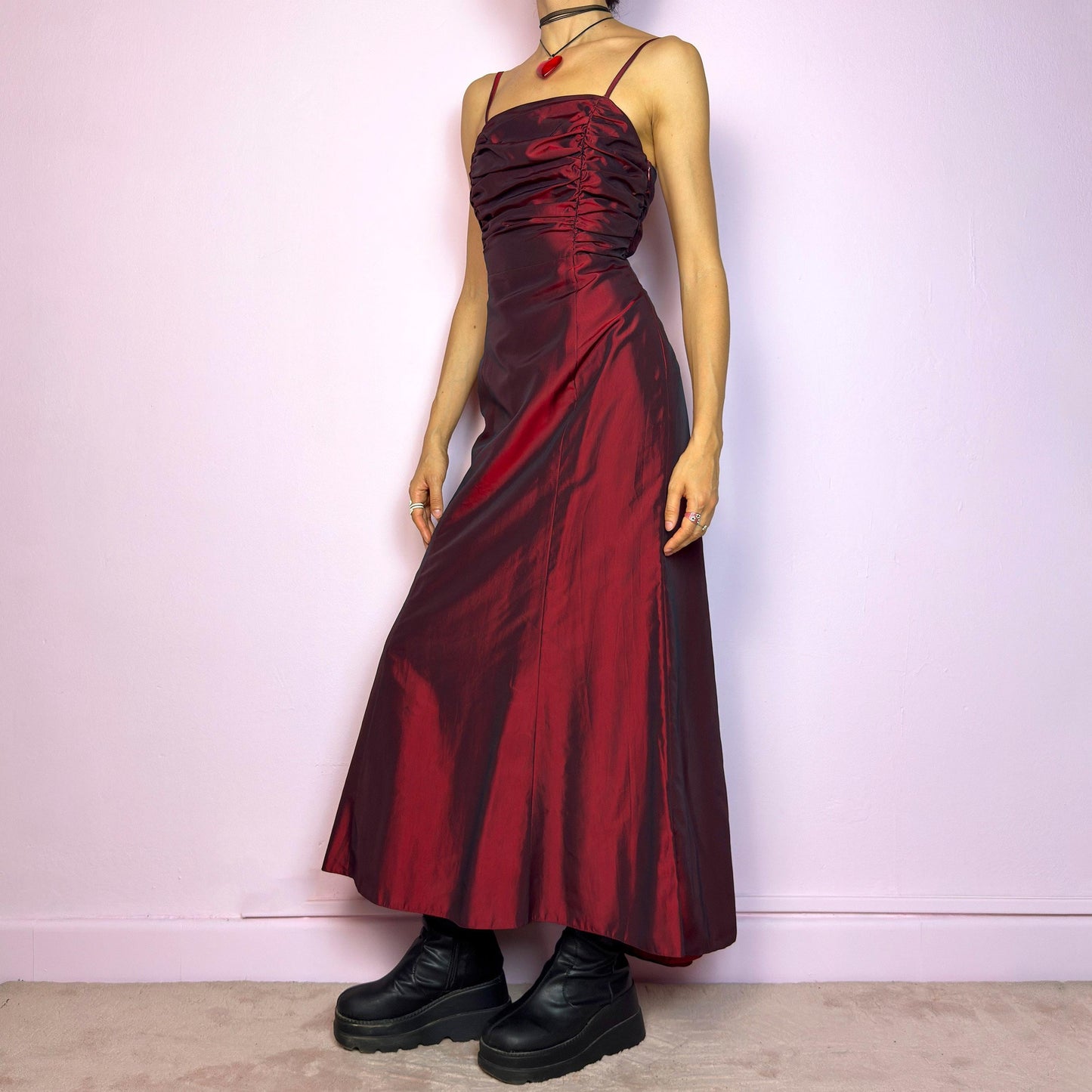 The Vintage 90s Burgundy Ruched Maxi Dress is a show-stopping piece featuring a rich burgundy tone with a lustrous satin-style finish. The ruched bodice adds texture and dimension, while the fitted silhouette flows into a soft A-line skirt. Designed with dainty spaghetti straps, a maxi length for dramatic flair, and a hidden side zipper closure for a seamless fit. Perfect for prom, formal events, or romantic night-outs. Excellent vintage condition.