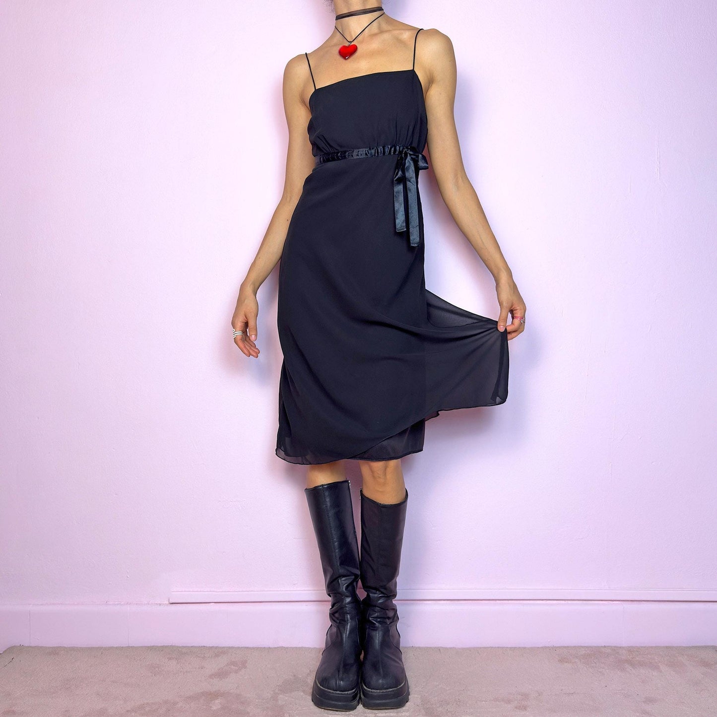 The Y2K Black Slip Midi Dress is a vintage 2000s dreamy minimalist piece featuring a lightweight sheer overlay, spaghetti straps, a flattering empire waist with a satin tie, and a classic midi silhouette. The lightweight, flowy fabric creates beautiful movement, making it perfect for party looks and romantic evenings. Classic, versatile, and effortlessly chic. Great vintage condition.