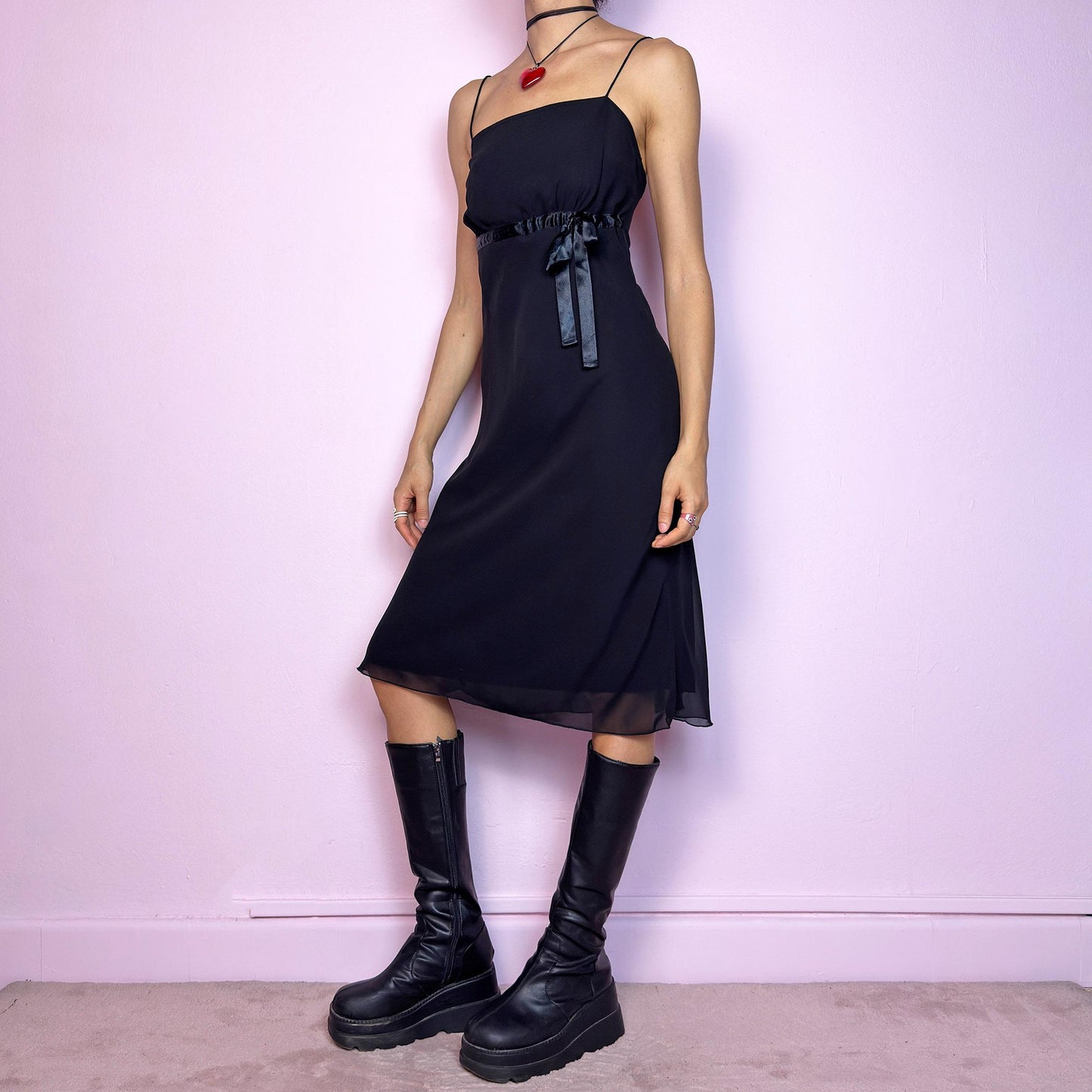 The Y2K Black Slip Midi Dress is a vintage 2000s dreamy minimalist piece featuring a lightweight sheer overlay, spaghetti straps, a flattering empire waist with a satin tie, and a classic midi silhouette. The lightweight, flowy fabric creates beautiful movement, making it perfect for party looks and romantic evenings. Classic, versatile, and effortlessly chic. Great vintage condition.