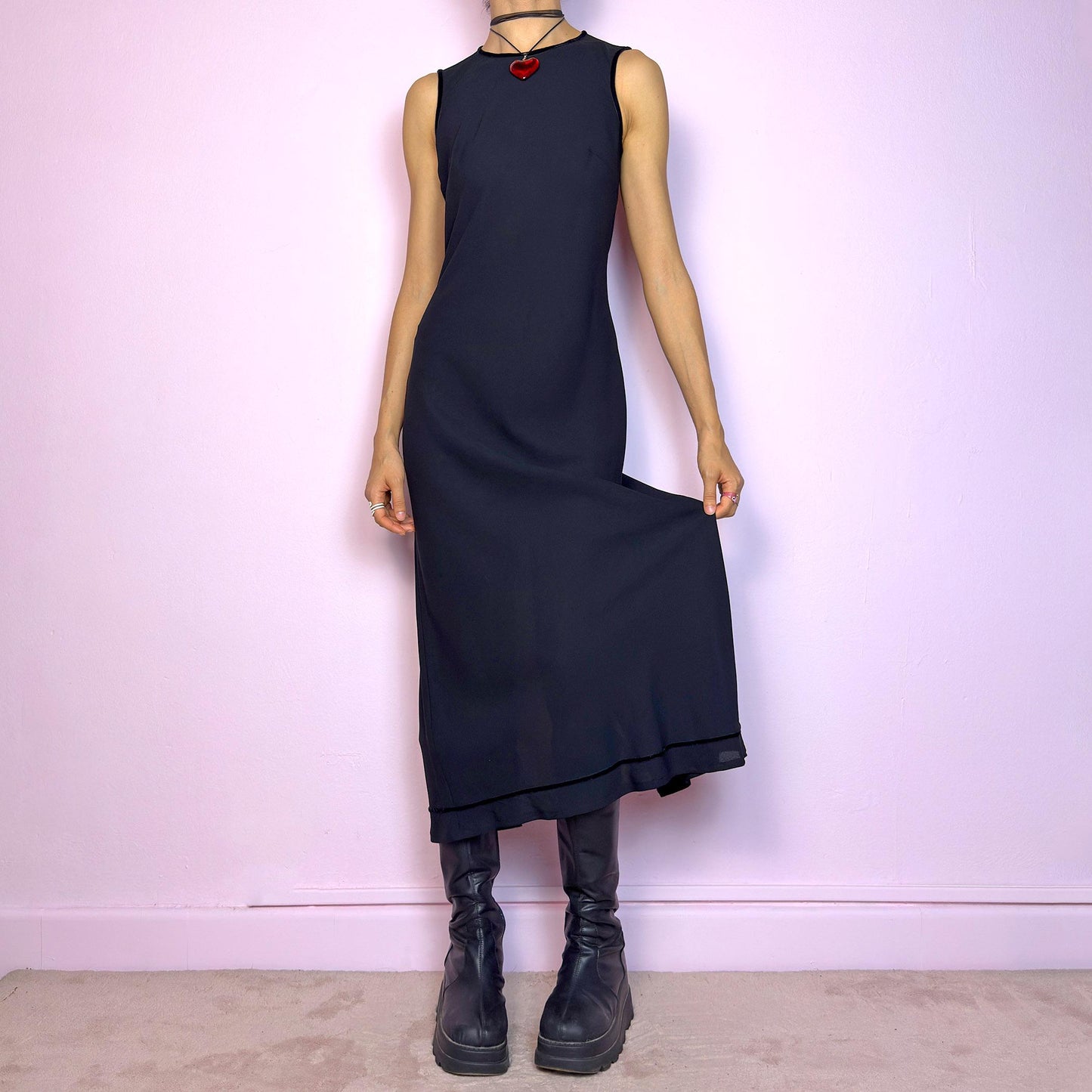 The Y2K Minimalist Black Midi Dress is a vintage 2000s sleek and timeless piece featuring a sleeveless design, and a slim, flattering fit. Crafted with lightweight, slightly sheer fabric, it drapes beautifully along the body and ends in a classic midi length. Features a back zipper closure and a back slit for ease of movement and an elegant touch. Perfect for minimalist, officecore, or elegant 90s-inspired looks. Effortlessly versatile for both casual layering and dressier night-out outfits.