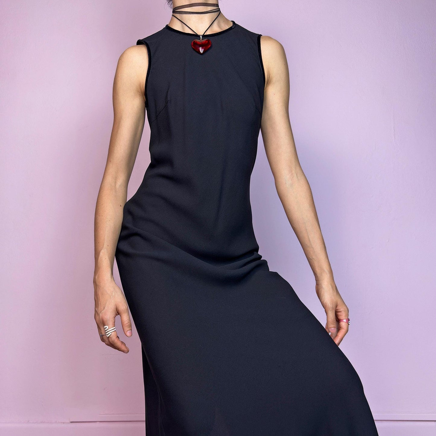 The Y2K Minimalist Black Midi Dress is a vintage 2000s sleek and timeless piece featuring a sleeveless design, and a slim, flattering fit. Crafted with lightweight, slightly sheer fabric, it drapes beautifully along the body and ends in a classic midi length. Features a back zipper closure and a back slit for ease of movement and an elegant touch. Perfect for minimalist, officecore, or elegant 90s-inspired looks. Effortlessly versatile for both casual layering and dressier night-out outfits.