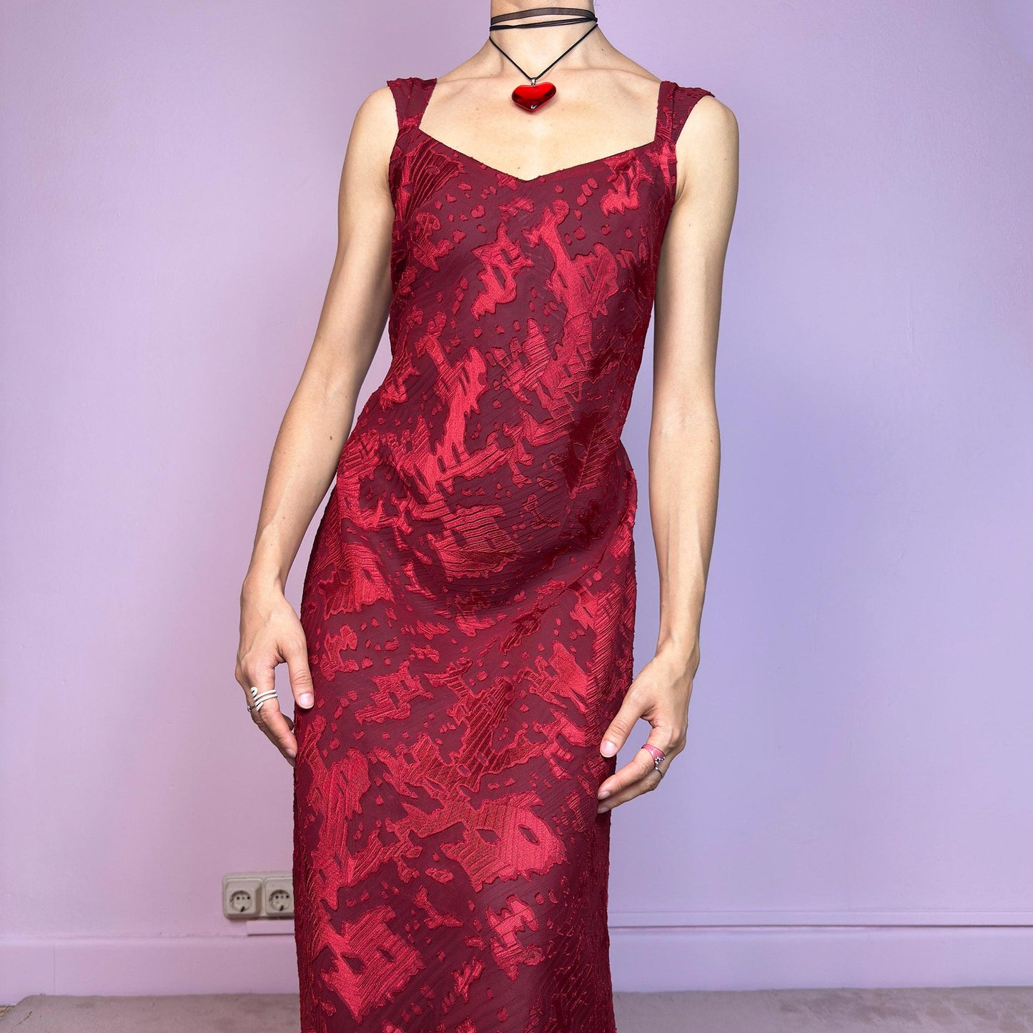The Vintage 90s Maroon Textured Midi Dress is a romantic and striking piece in a rich maroon tone with abstract textured patterns and a sheer overlay. Designed with wide straps, a flattering sweetheart neckline, and a flowy midi-length cut. The semi-sheer fabric adds depth while the inner lining provides comfort. Perfect for formal events, romantic nights, or gothic glam looks. Elegant, timeless, and effortlessly dramatic. Excellent vintage condition.
