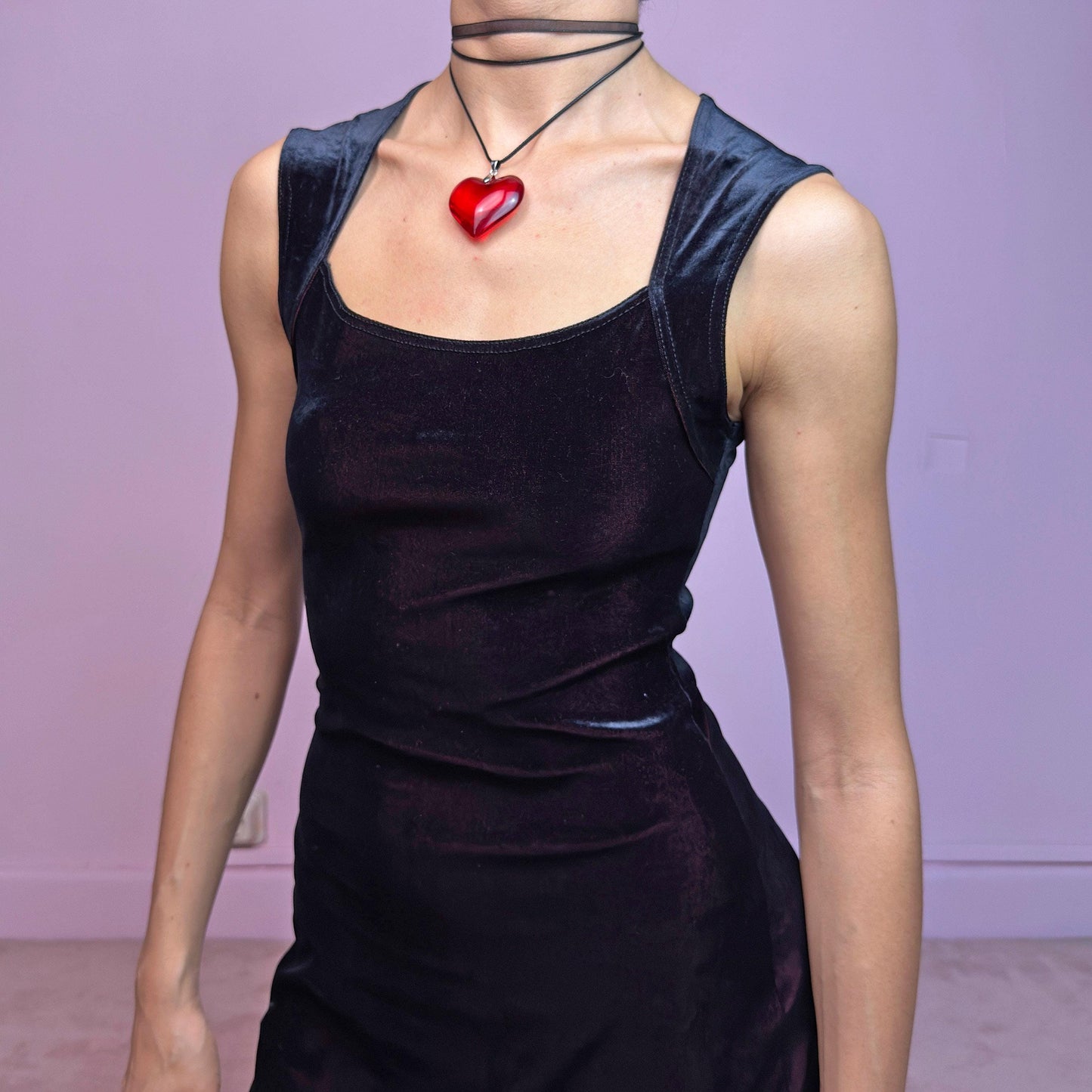 The Vintage 90s Black Velvet Midi Dress is pure elegance with a twist. Crafted from deep black velvet with a maroon undertone, it catches the light with rich, dark burgundy reflections that give it a luxe finish. Features wide straps, a square neckline, and a body-hugging midi silhouette that flatters and elongates. Soft and stretchy for comfort, yet bold and dramatic for gothic, romantic, or night-out looks. A subtly striking piece that stands out in movement and moonlight.