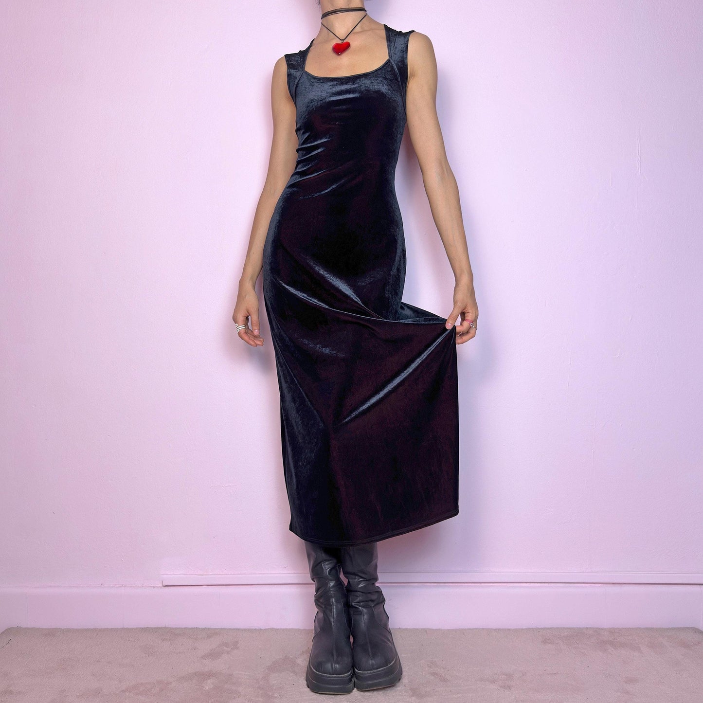 The Vintage 90s Black Velvet Midi Dress is pure elegance with a twist. Crafted from deep black velvet with a maroon undertone, it catches the light with rich, dark burgundy reflections that give it a luxe finish. Features wide straps, a square neckline, and a body-hugging midi silhouette that flatters and elongates. Soft and stretchy for comfort, yet bold and dramatic for gothic, romantic, or night-out looks. A subtly striking piece that stands out in movement and moonlight.