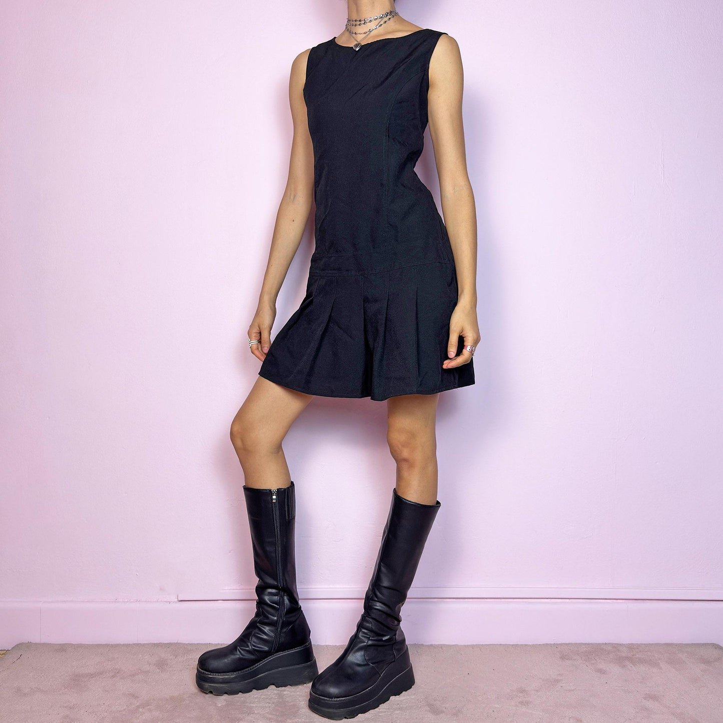 The Y2K Black Pleated Mini Dress is minimalist dream with a preppy edge. This vintage 2000s dress features a structured sleeveless bodice, subtle diagonal dart details, a pleated mini skirt that adds playful movement and a side zipper closure. The clean silhouette makes it perfect for layering or styling solo, giving off major dark academia and coquette vibes. A wardrobe staple for any lover of sleek, 2000s fashion. Great vintage condition.