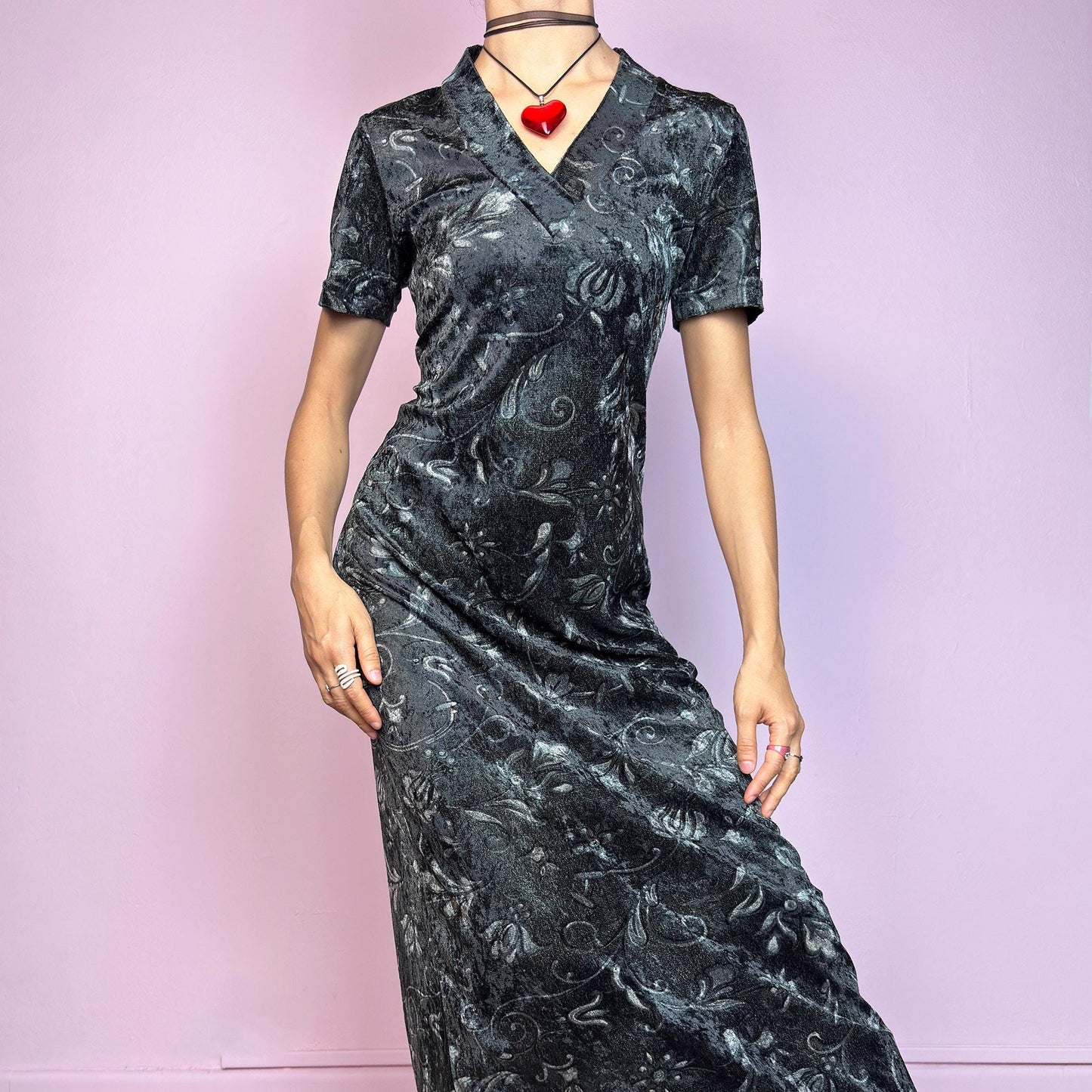 The Vintage 90s Gray Velvet Midi Dress is a moody and elegant 90s piece made from soft, stretchy dark gray velvet with a baroque-style printed pattern. Features a flattering V-neckline, short sleeves, and a sleek longline silhouette. The velvety fabric gives it a luxurious feel while staying comfy. Perfect for witchy aesthetics, gothic romance, or vintage night-out looks.