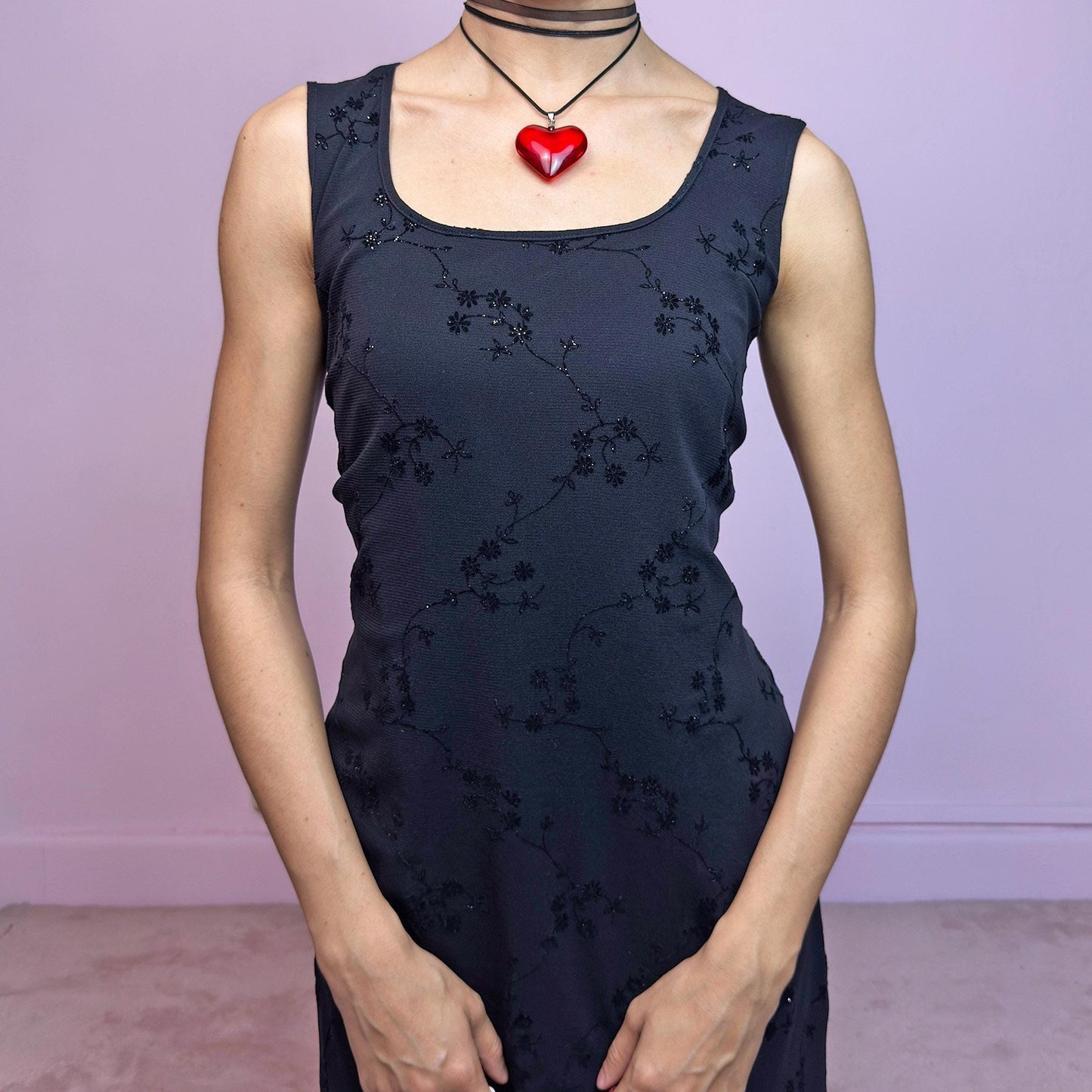 The Vintage 90s Black Mesh Mini Dress is a delicate and stretchy black mini dress featuring sheer mesh overlay with velvet floral embroidery and subtle glitter accents. Designed with a flattering sleeveless silhouette, scoop neckline, and lettuce hem for a soft romantic touch. Perfect for witchy party looks, 90s glam nights, or layering with grunge accessories. Made in UK. Excellent vintage condition.