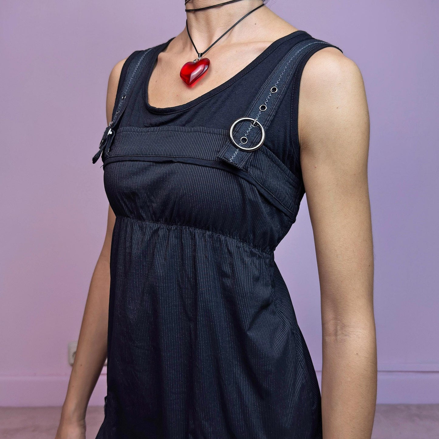 The Y2K Black Striped Bubble Mini Dress is a rare vintage 2000s piece with a playful techwear vibe. Features subtle vertical pinstripes, silver-tone D-rings on the straps, and functional side pockets. The ruched bubble hem adds volume and edge, while the stretchy fabric and empire waist provide a flattering fit. Finished with a side zipper closure for easy wear. Perfect for cybercore, Y2K streetwear, or Harajuku-inspired looks. Excellent vintage condition.