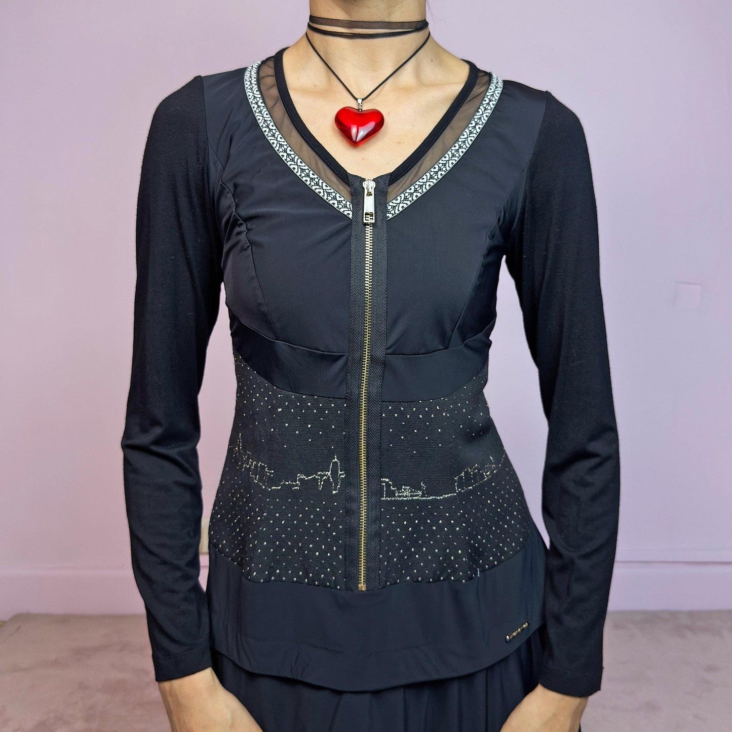 The Y2K Black Long Sleeve Mini Dress is a vintage 2000s sleek and deconstructed mini dress featuring a fitted bodice with a front zipper and a glittery cityscape detail at the waist. The long sleeves balance the edgy vibe of the layered, asymmetrical skirt, giving it a sculptural silhouette. Stretchy and comfortable, this dress is perfect for cybercore and futuristic clubwear. Great vintage condition.