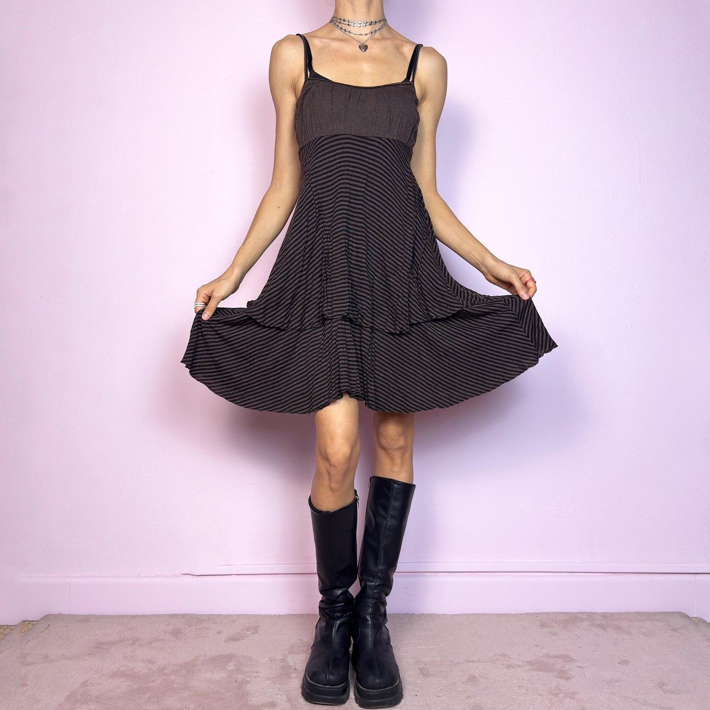 This vintage 2000s brown midi dress features a fine black stripe pattern, square neckline, and thin shoulder straps. Made from a soft, stretchy knit, it has an empire waist and a tiered asymmetric hem that drapes with ease. Perfect for summer. A casual, fairy grunge–inspired piece with subtle volume and flow—blending comfort, minimalism, and quiet edge. Great vintage condition.