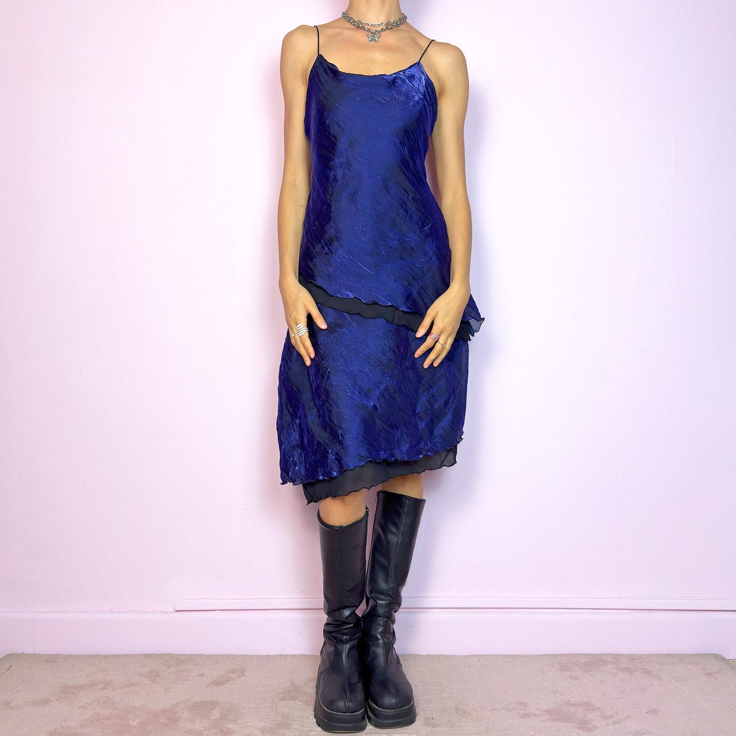 This vintage 90s midi dress features rich cobalt blue crinkled fabric over a black base with asymmetric layered panels. The fluid A-line silhouette and thin spaghetti straps create soft movement and luminous drape. Made from lightweight material with no stretch. A romantic and timeless piece for formal summer occasions—elegant, sculptural, and made to be remembered. Excellent vintage condition.