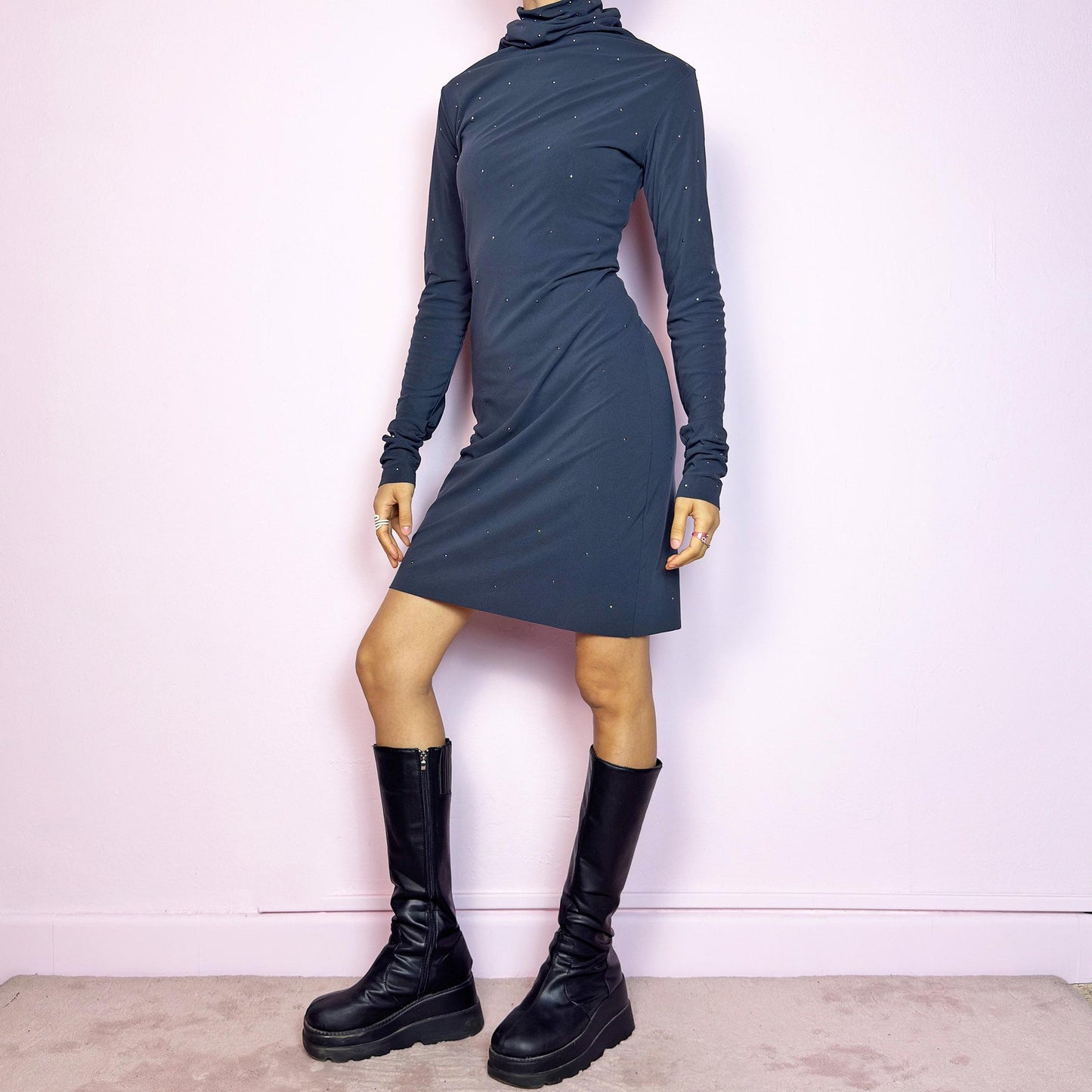 This vintage 2000s grey mini dress is cut from stretchy mesh jersey with an elegant turtleneck and long sleeves. Subtle rhinestones are scattered throughout, catching light with a soft shimmer. The bodycon silhouette hugs the figure with ease. No closure, easy pull-on style. A minimalist Y2K piece with glam undertones—perfect for winter nights, parties, or city outings. Made in Italy. Excellent vintage condition.