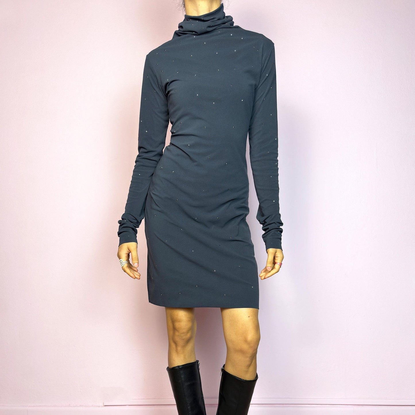 This vintage 2000s grey mini dress is cut from stretchy mesh jersey with an elegant turtleneck and long sleeves. Subtle rhinestones are scattered throughout, catching light with a soft shimmer. The bodycon silhouette hugs the figure with ease. No closure, easy pull-on style. A minimalist Y2K piece with glam undertones—perfect for winter nights, parties, or city outings. Made in Italy. Excellent vintage condition.