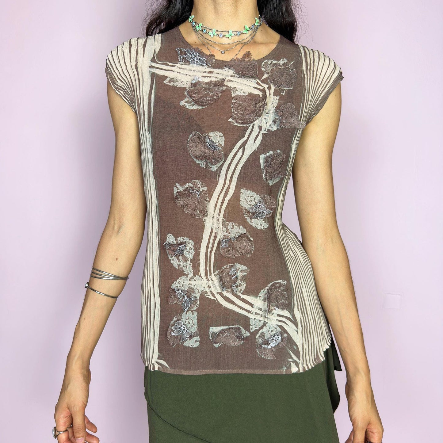 This vintage 1990s semi-sheer crinkled pleated sleeveless top features an abstract vine and lace motif in soft taupe brown and beige. An ethereal avant-garde piece with architectural flow and botanical texture—rare and striking, ideal for summer artsy events. Made of polyester. Excellent vintage condition.