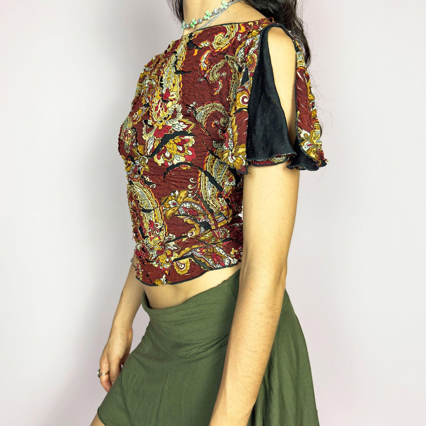 This vintage 2000s crinkle mesh top stuns with yellow-gold paisley prints on a rich maroon base and a dramatic split short sleeve. Ideal for summer nights, art parties, or elegant outdoor dinner looks. A rare, textile-rich piece with gypsy-bohemian undertones and free-spirited dancing energy. Made of stretch polyester blend. Great vintage condition.