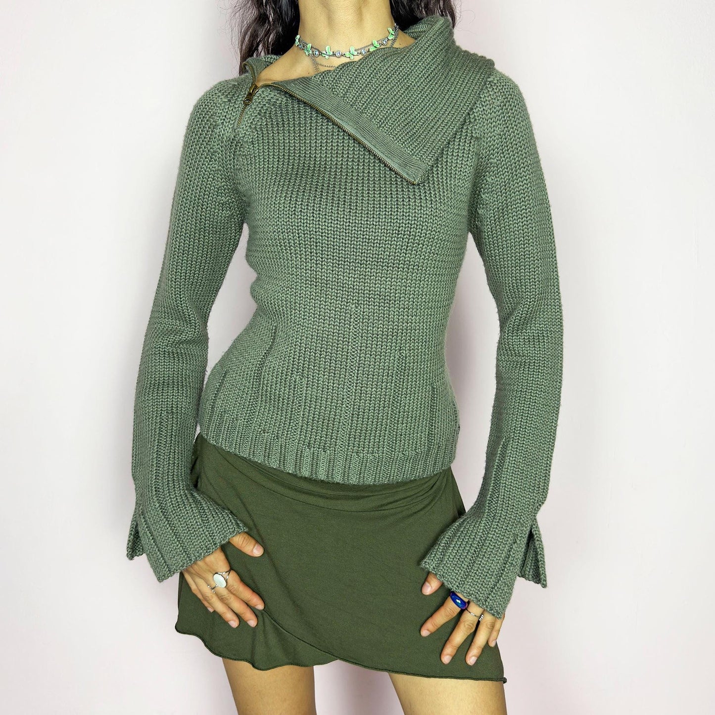 This vintage 2000s green knit sweater features a dramatic asymmetrical collar with exposed zipper and flared split cuffs. Ideal for deconstructed layering on autumn days, it radiates fairy grunge energy with a streetwear edge. A fluffy Y2K piece made of acrylic and wool for cozy warmth. Great vintage condition.