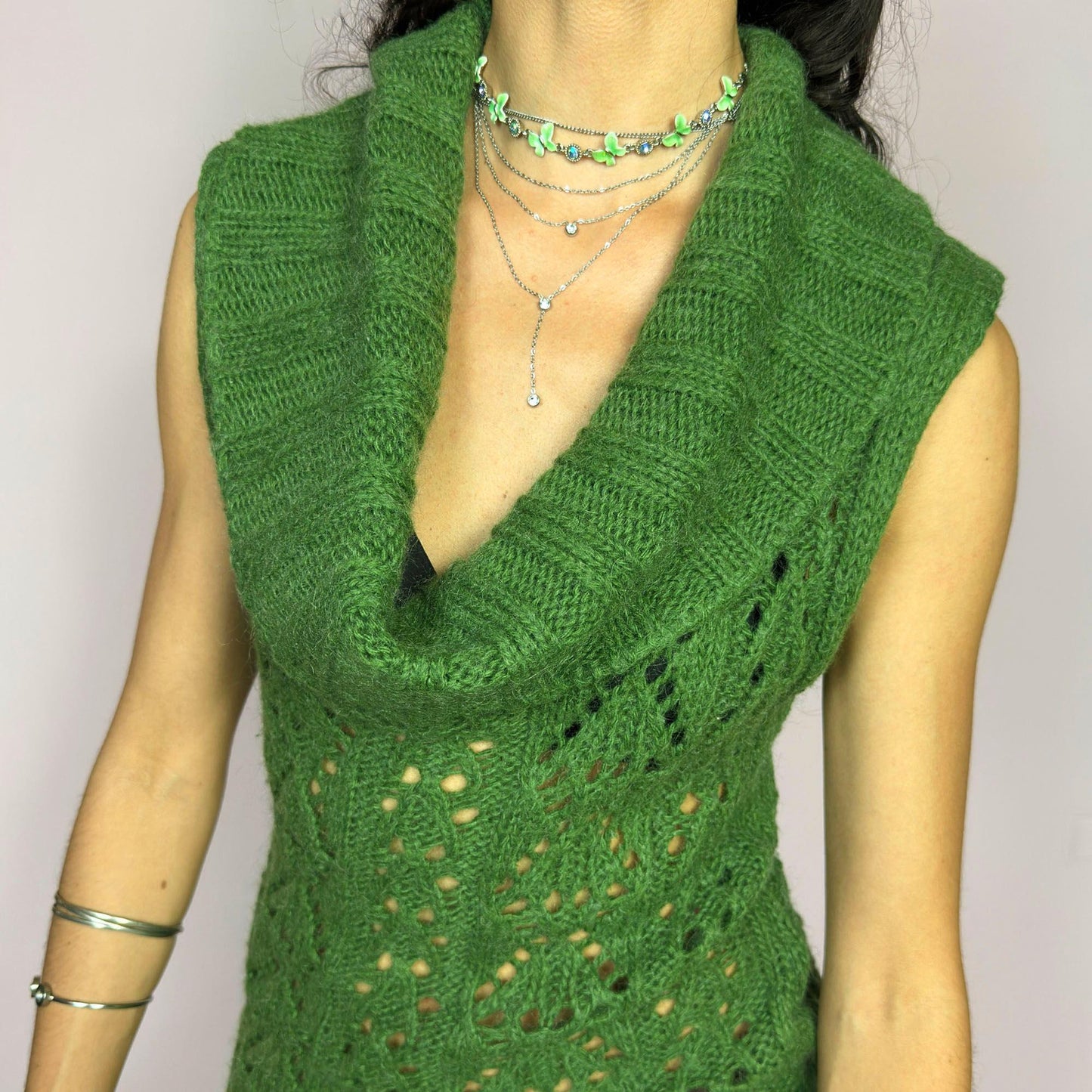 This vintage 2000s green knit mini dress features a dramatic cowl neckline, sleeveless cut, and decorative open knit pattern through the torso. Softly fitted and slightly sheer—perfect for lounging by the fire on a rustic weekend escape. A super comfy Y2K piece made in Spain. Made from an acrylic, polyamide, and mohair blend for soft warmth. Great vintage condition.
