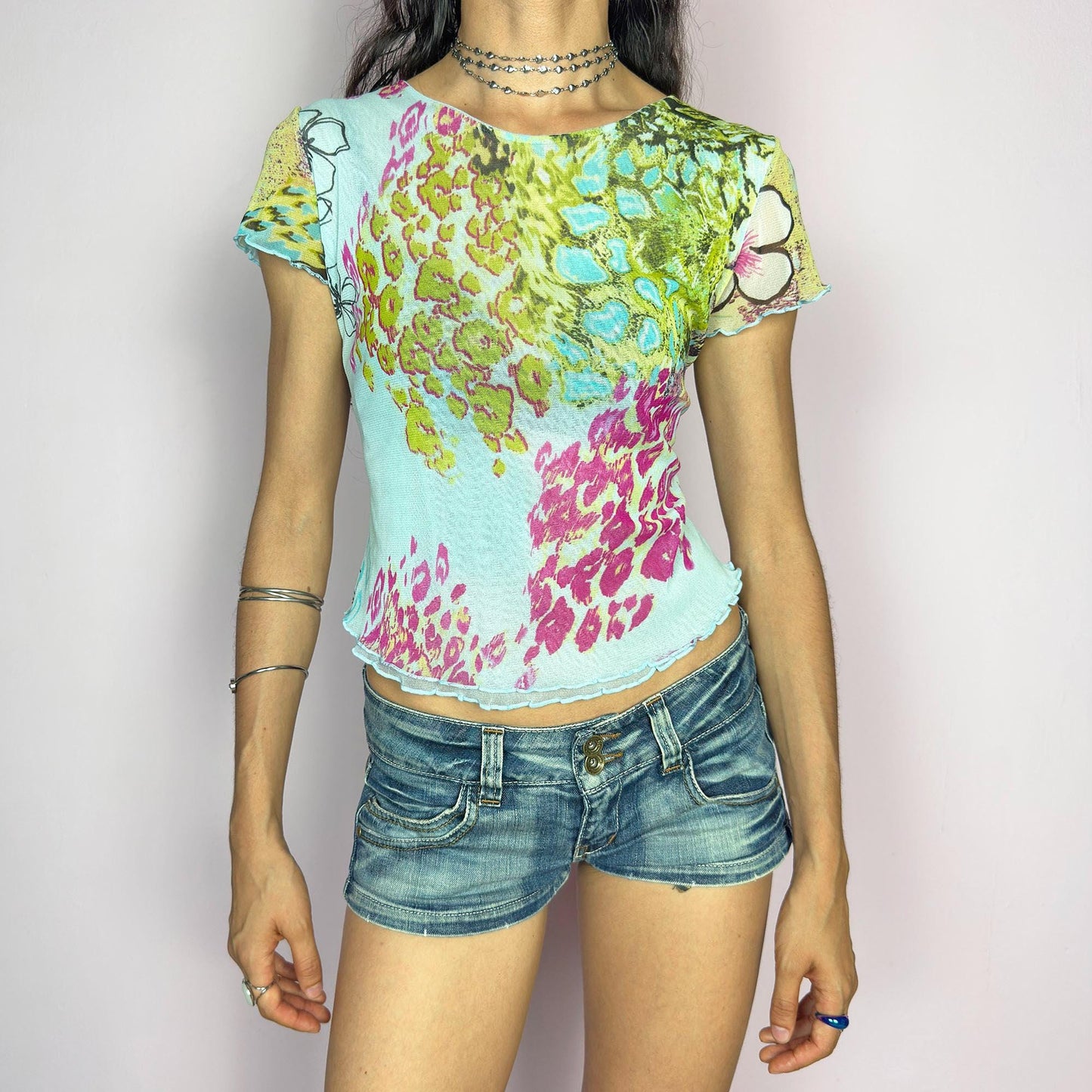 This vintage 2000s soft semi-sheer mesh tee bursts with pastel animal prints in pistachio, aqua, pink, and fuchsia over a baby blue base. The graphic collage is finished with delicate lettuce edging at the sleeves and hem. Perfect for summer festivals, casual layering, or a sunny day ice cream outing. A super cute, collectible Y2K piece with sweet attitude. Made of stretch polyester mesh from a French brand. Excellent vintage condition.
