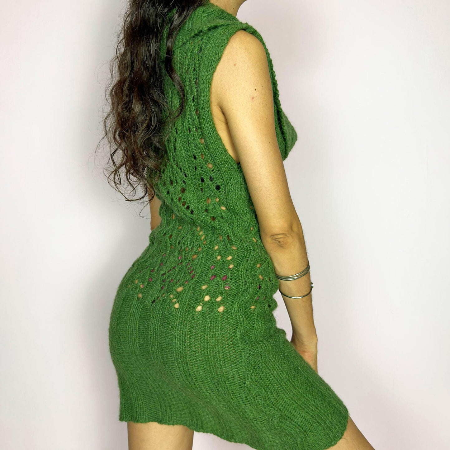 This vintage 2000s green knit mini dress features a dramatic cowl neckline, sleeveless cut, and decorative open knit pattern through the torso. Softly fitted and slightly sheer—perfect for lounging by the fire on a rustic weekend escape. A super comfy Y2K piece made in Spain. Made from an acrylic, polyamide, and mohair blend for soft warmth. Great vintage condition.