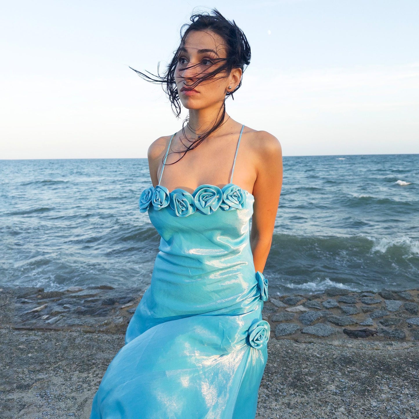 The vintage 2000s blue slip dress is a French-made fantasy with sculptural rosette appliqué along the bust and ruched side detail. Its iridescent finish and fluid midi length evoke a dreamy softness, perfect for proms, summer weddings, or romantic evenings. The silhouette is both delicate and structured, capturing quiet glamour with fairytale allure. A romantic Y2K archive crafted from a shimmering non-stretch fabric. Great vintage condition.