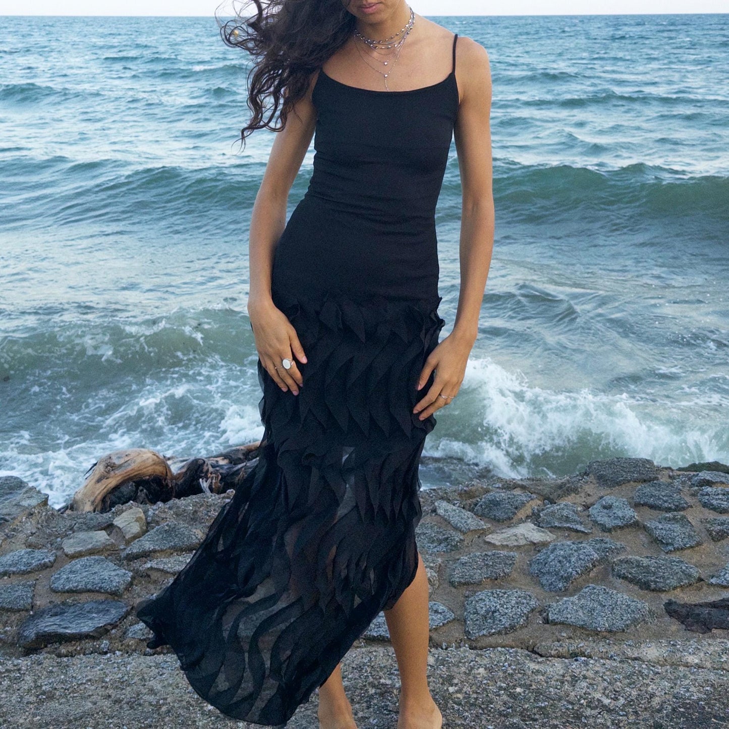 The vintage 90s black mesh midi dress is a sculptural piece with sheer wave appliqué layered across the skirt, minimalist neckline, and a back slit for fluidity. Its body-skimming silhouette fuses quiet sensuality with architectural edge. Ideal for city nights, gallery parties, or modern cocktail looks. An avant garde archive find made in the USA from a stretchy polyester blend. Excellent vintage condition.