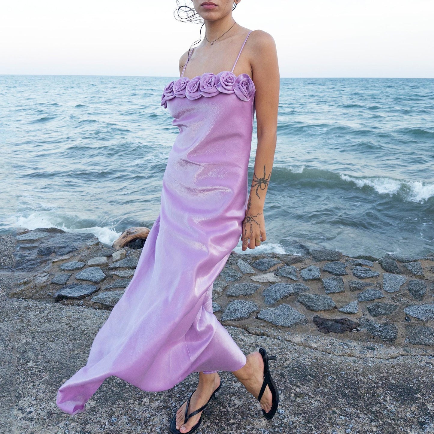 The vintage 2000s pastel lilac slip dress is a French-made fantasy with sculptural rosette appliqué along the bust. Its iridescent finish and fluid midi length evoke dreamy softness, perfect for proms, summer weddings, or romantic evenings. The silhouette captures fairytale allure with quiet glamour. A romantic Y2K archive crafted from a shimmering non-stretch polyester blend fabric. Excellent vintage condition.