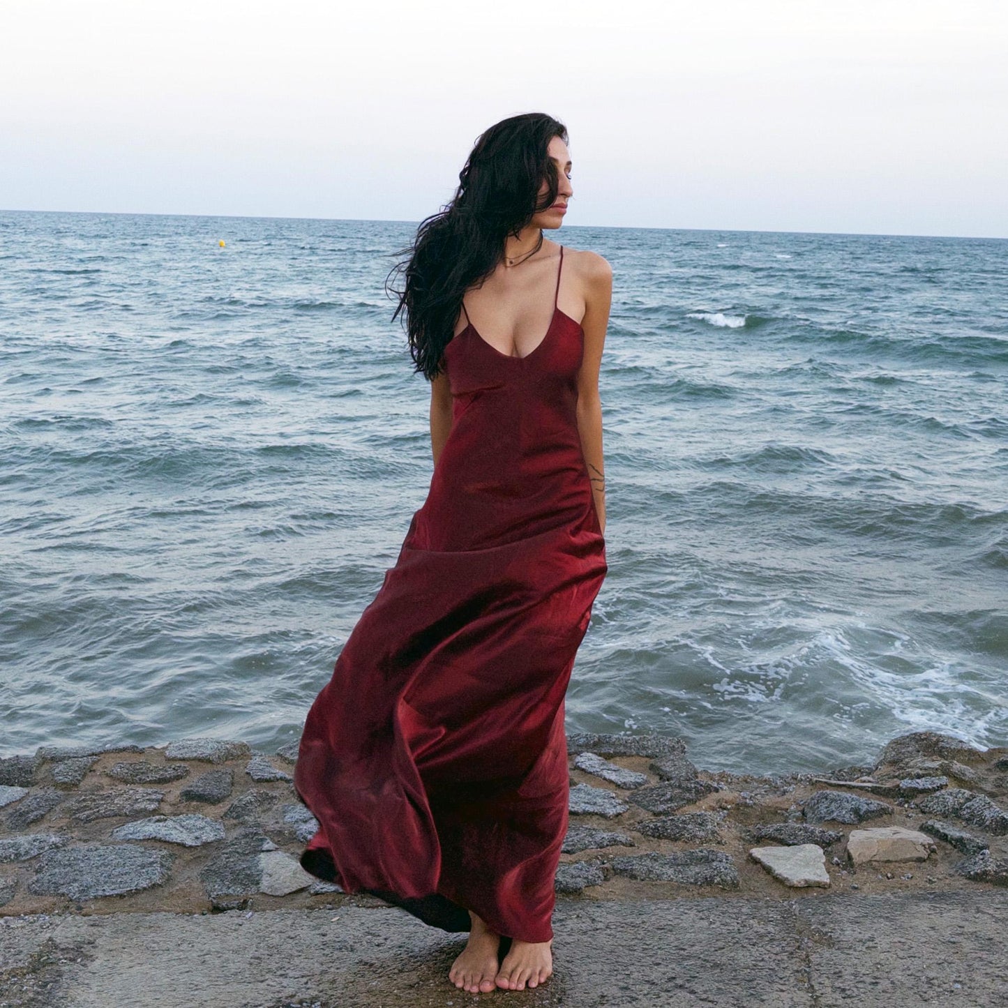 The vintage 2000s maroon slip dress is a French-made piece with high-shine finish, fluid silhouette, and delicate spaghetti straps. Its glossy depth and body-skimming cut evoke diva glamour and red carpet allure. Ideal for summer nights, cocktails, or sensual evening entrances. A romantic burgundy Y2K archive gown made from a non-stretch polyester blend fabric. Excellent vintage condition.