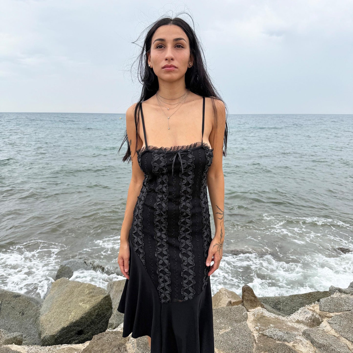 This vintage 2000s black midi dress features an asymmetrical handkerchief hem with whimsical flow and delicate mesh panel details through the bodice. Crafted in France from a stretchy polyester blend, it hugs the figure while allowing movement. A romantic dark piece with fairy, witchy, and night-party energy—perfect for Y2K alternative styling. Made from polyester stretch blend. Excellent vintage condition.