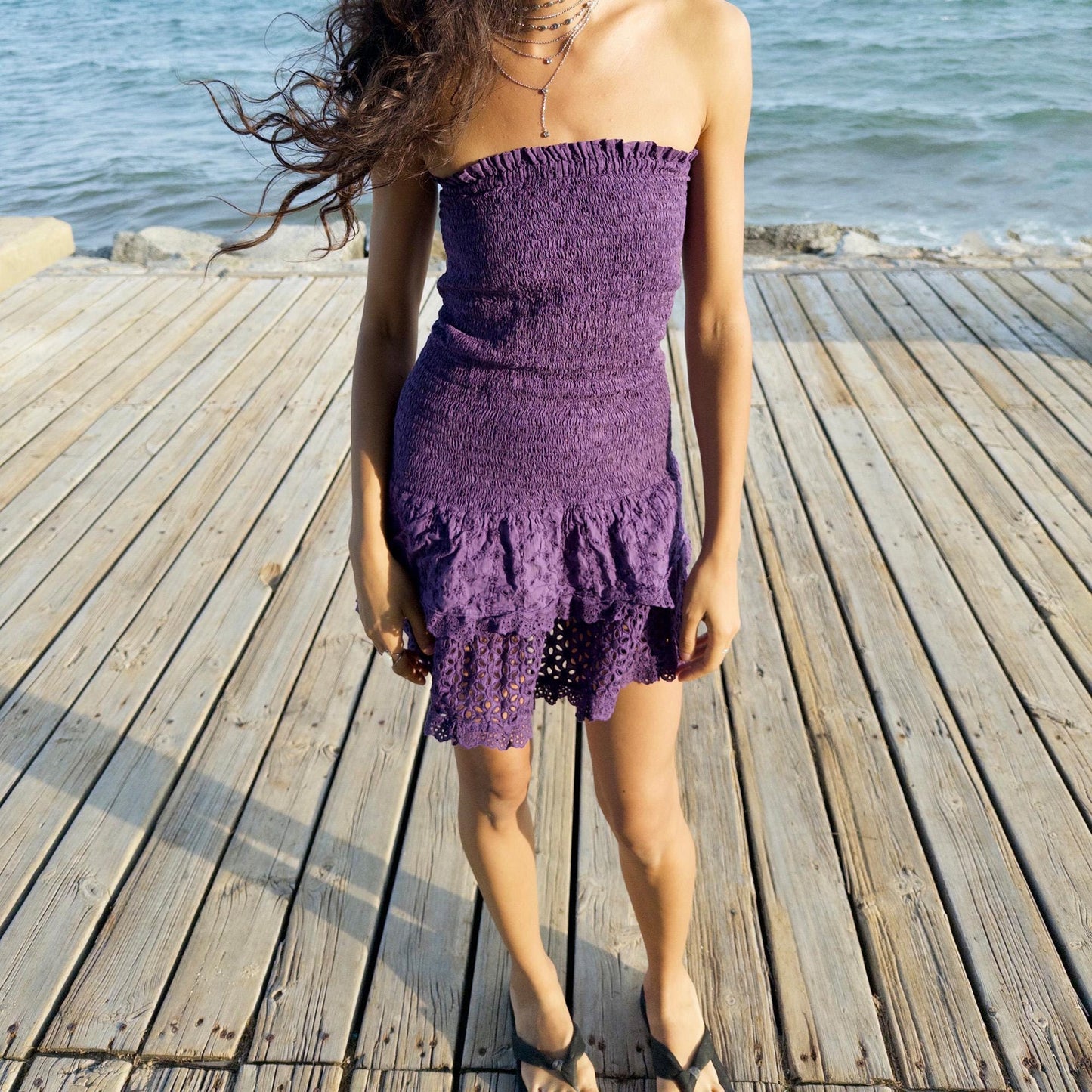 The vintage 90s purple strapless mini dress is a sunlit dream in ruched cotton with tiered ruffle lace hems. Made in Italy, its smocked bodice hugs the figure while the eyelet and broderie anglaise layers add texture and movement. Lightweight and easy, it channels boho fairy energy—perfect for holidays, summer parties, or barefoot cocktail hours. A romantic resort piece with sun-drenched charm. Great vintage condition.