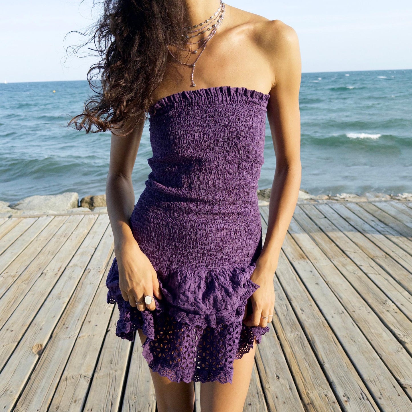 The vintage 90s purple strapless mini dress is a sunlit dream in ruched cotton with tiered ruffle lace hems. Made in Italy, its smocked bodice hugs the figure while the eyelet and broderie anglaise layers add texture and movement. Lightweight and easy, it channels boho fairy energy—perfect for holidays, summer parties, or barefoot cocktail hours. A romantic resort piece with sun-drenched charm. Great vintage condition.