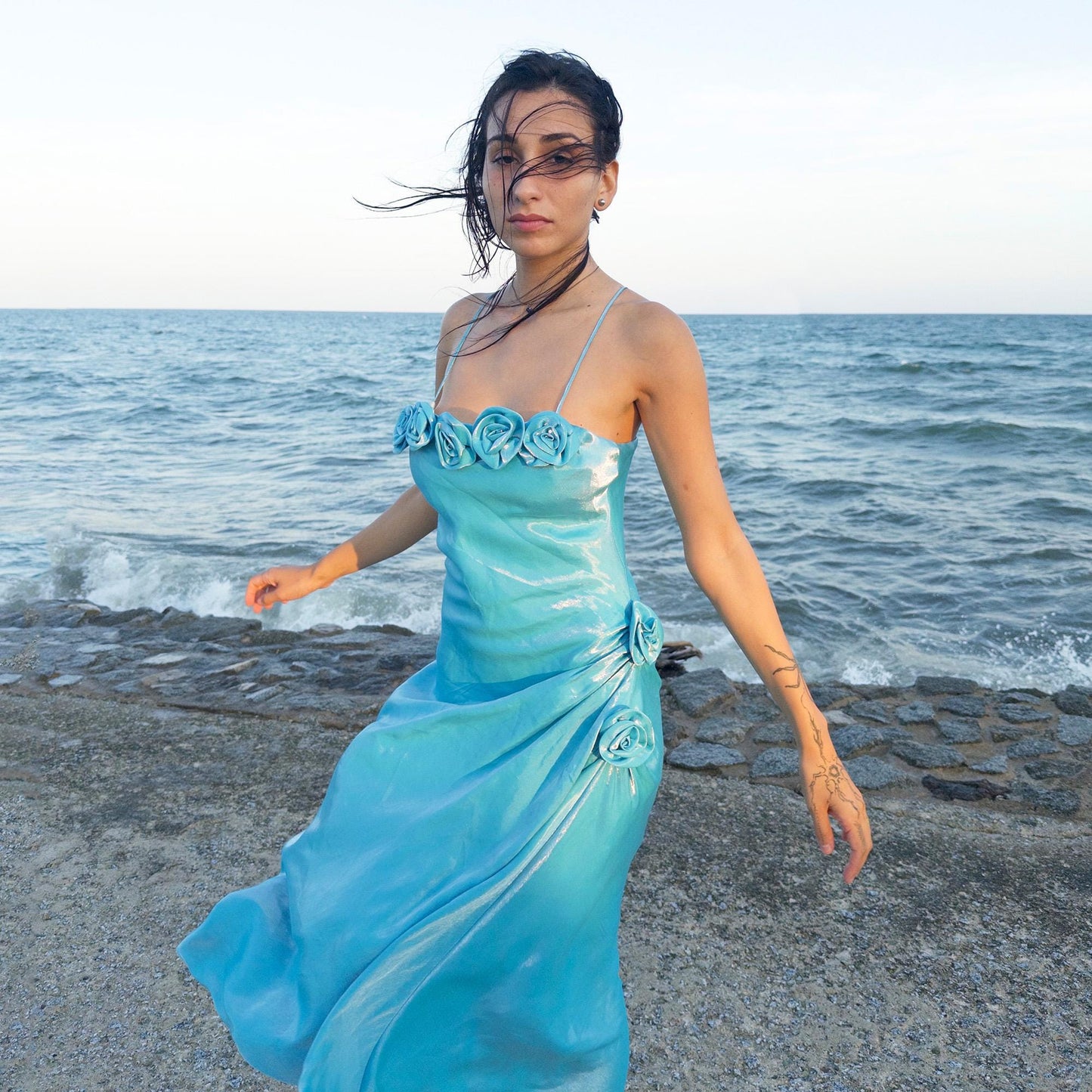 The vintage 2000s blue slip dress is a French-made fantasy with sculptural rosette appliqué along the bust and ruched side detail. Its iridescent finish and fluid midi length evoke a dreamy softness, perfect for proms, summer weddings, or romantic evenings. The silhouette is both delicate and structured, capturing quiet glamour with fairytale allure. A romantic Y2K archive crafted from a shimmering non-stretch fabric. Great vintage condition.