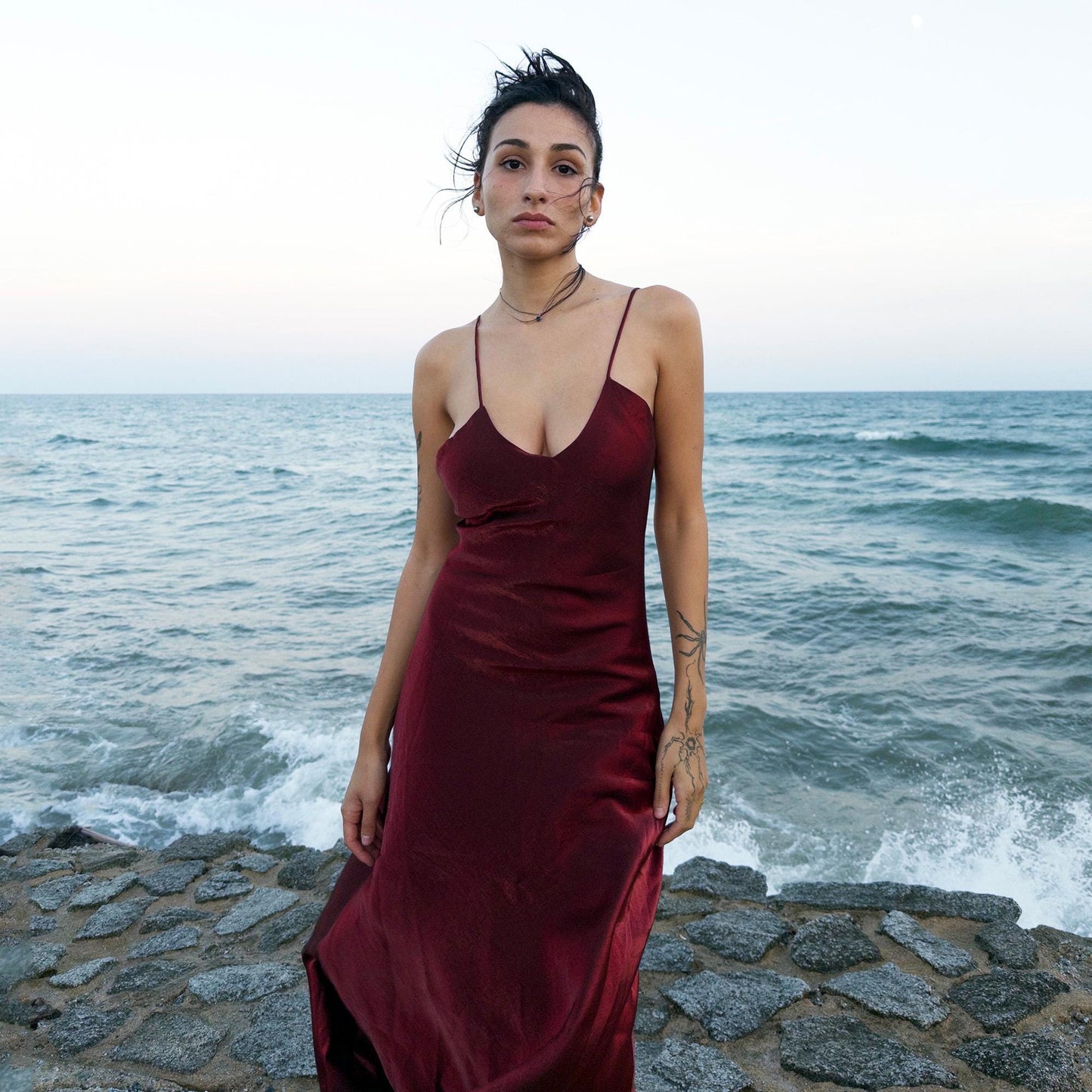 The vintage 2000s maroon slip dress is a French-made piece with high-shine finish, fluid silhouette, and delicate spaghetti straps. Its glossy depth and body-skimming cut evoke diva glamour and red carpet allure. Ideal for summer nights, cocktails, or sensual evening entrances. A romantic burgundy Y2K archive gown made from a non-stretch polyester blend fabric. Excellent vintage condition.