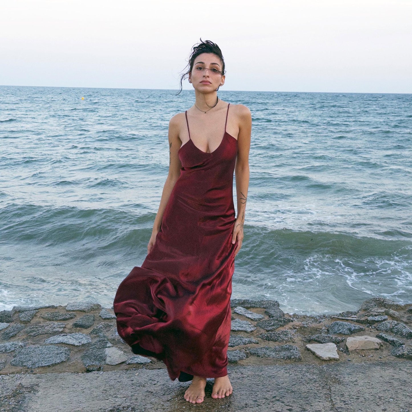 The vintage 2000s maroon slip dress is a French-made piece with high-shine finish, fluid silhouette, and delicate spaghetti straps. Its glossy depth and body-skimming cut evoke diva glamour and red carpet allure. Ideal for summer nights, cocktails, or sensual evening entrances. A romantic burgundy Y2K archive gown made from a non-stretch polyester blend fabric. Excellent vintage condition.