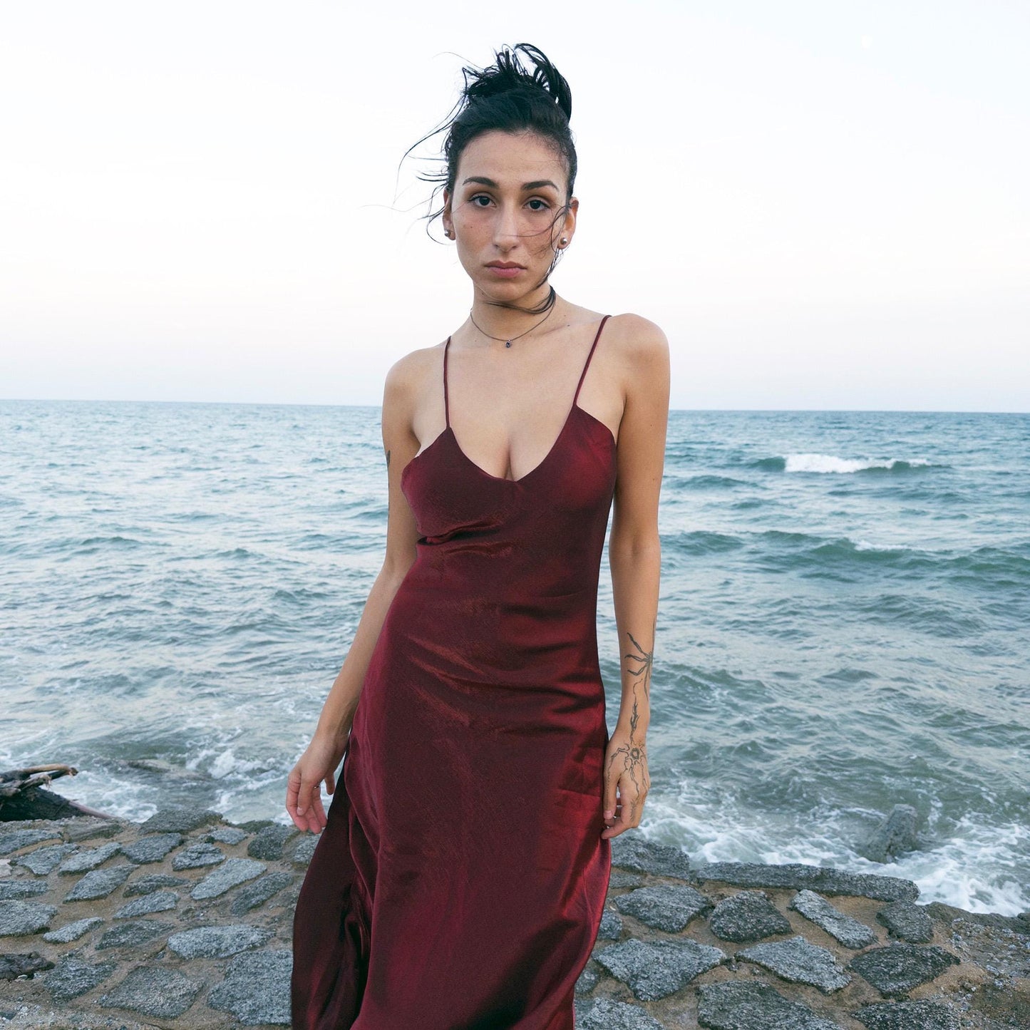 The vintage 2000s maroon slip dress is a French-made piece with high-shine finish, fluid silhouette, and delicate spaghetti straps. Its glossy depth and body-skimming cut evoke diva glamour and red carpet allure. Ideal for summer nights, cocktails, or sensual evening entrances. A romantic burgundy Y2K archive gown made from a non-stretch polyester blend fabric. Excellent vintage condition.