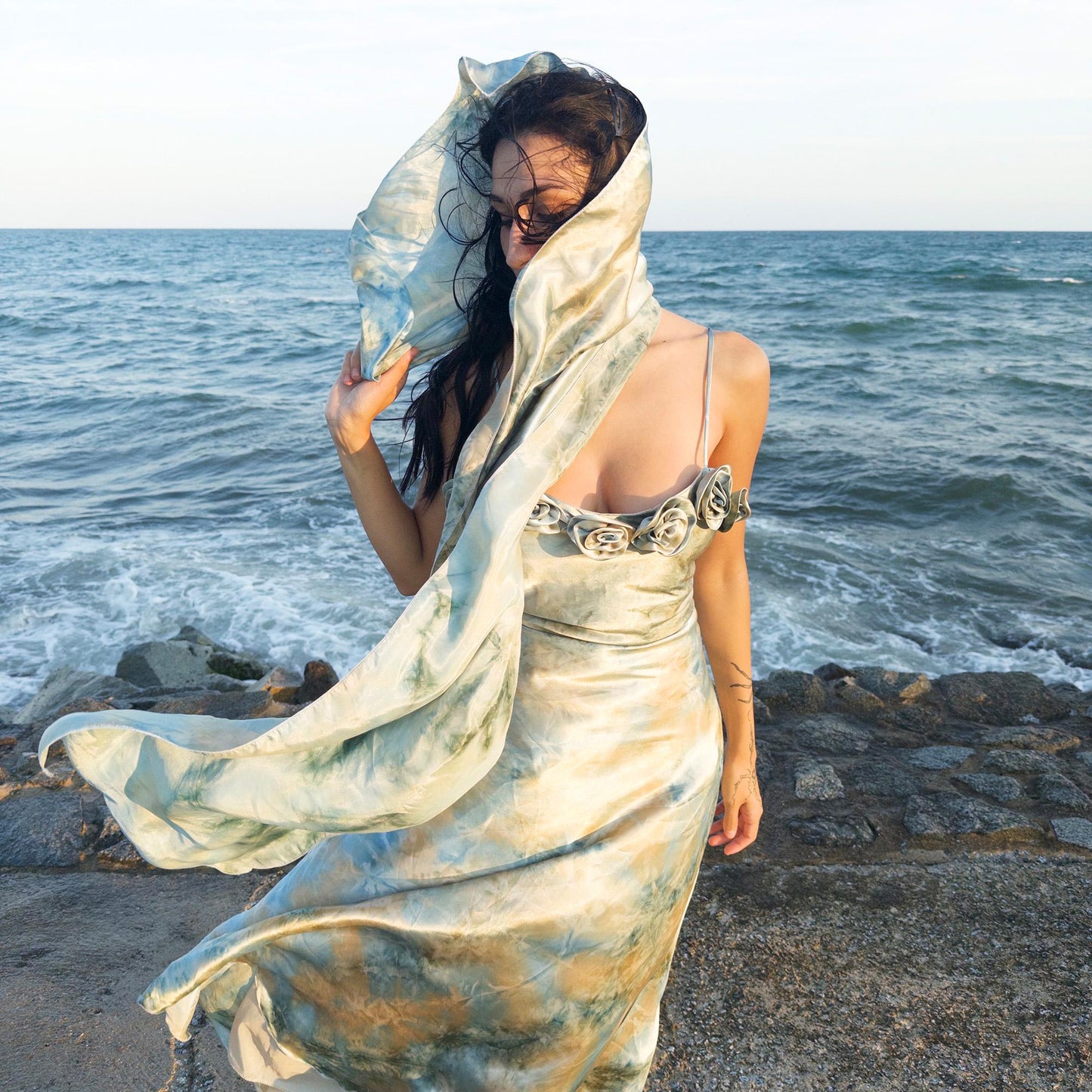 The vintage 2000s pastel tie-dye slip dress is a French-made fantasy in soft blues, greens, and gold. With sculptural rosette appliqué along the bust and a matching scarf, it moves like light on water. The shiny satin-style finish and fluid midi length evoke fairytale softness—ideal for proms, weddings, or summer nights. A romantic Y2K archive crafted from a shimmering non-stretch polyester blend. Great vintage condition.