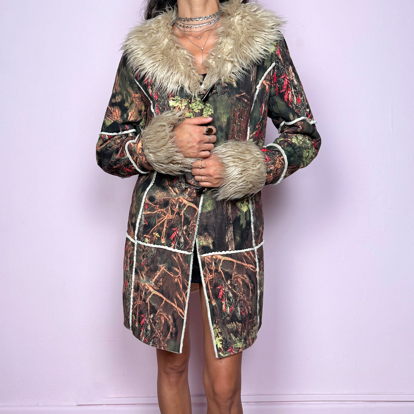 This vintage 2000s Penny Lane coat features a surreal forest graphic print in earthy greens, browns, and red tones, trimmed with plush beige faux fur at the collar and cuffs. Designed with toggle closures, contrast seams and pockets, it evokes fairycore and woodland Y2K energy with bohemian allure. Cozy yet bold, perfect for winter layering and statement street styling. A collectible archive outerwear piece. Made from warm polyester blend. Excellent vintage condition.