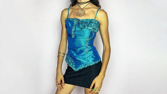 Vintage Y2K 2000s blue satin corset top with applique rosettes and beaded details, styled with black mini skirt.