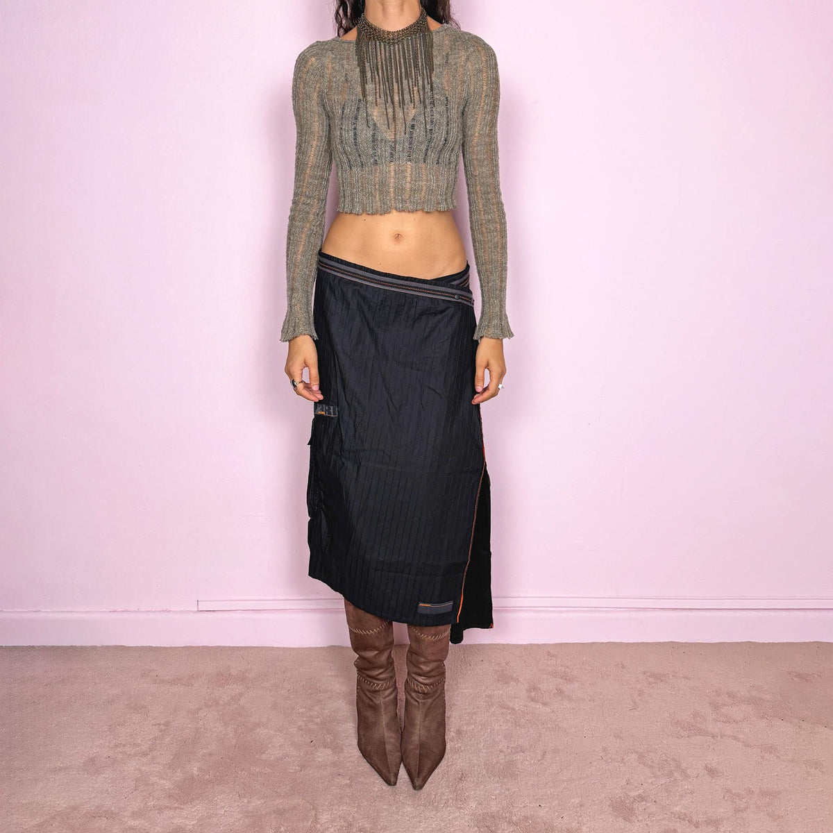 Vintage 2000s black midi skirt by French label Cop Copine, made from 100% cotton with no stretch. Features an asymmetric wrap-style construction, subtle vertical stripe texture, snap-button fastening at the waist, and a dramatic side slit with contrast topstitching. Finished with layered panel detailing for a deconstructed, utilitarian, dark avant-garde look. Can be worn mid-rise for size M or lower on the waist for size S. Excellent vintage condition.