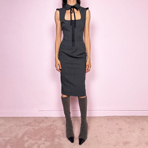 Vintage 2000s minimal preppy Dolce & Gabbana fitted pencil midi dress in gray tailoring fabric with slight stretch. Sculpted body-skimming silhouette with dramatic square cut out neckline, rounded collar with tie detail, subtle ruffled cap sleeves, front hook eye closure and side zip closure. Flattering secretary siren meets dark academia aesthetic. Made from a polyester viscose elastane blend with 97% silk lining. Excellent vintage condition.
